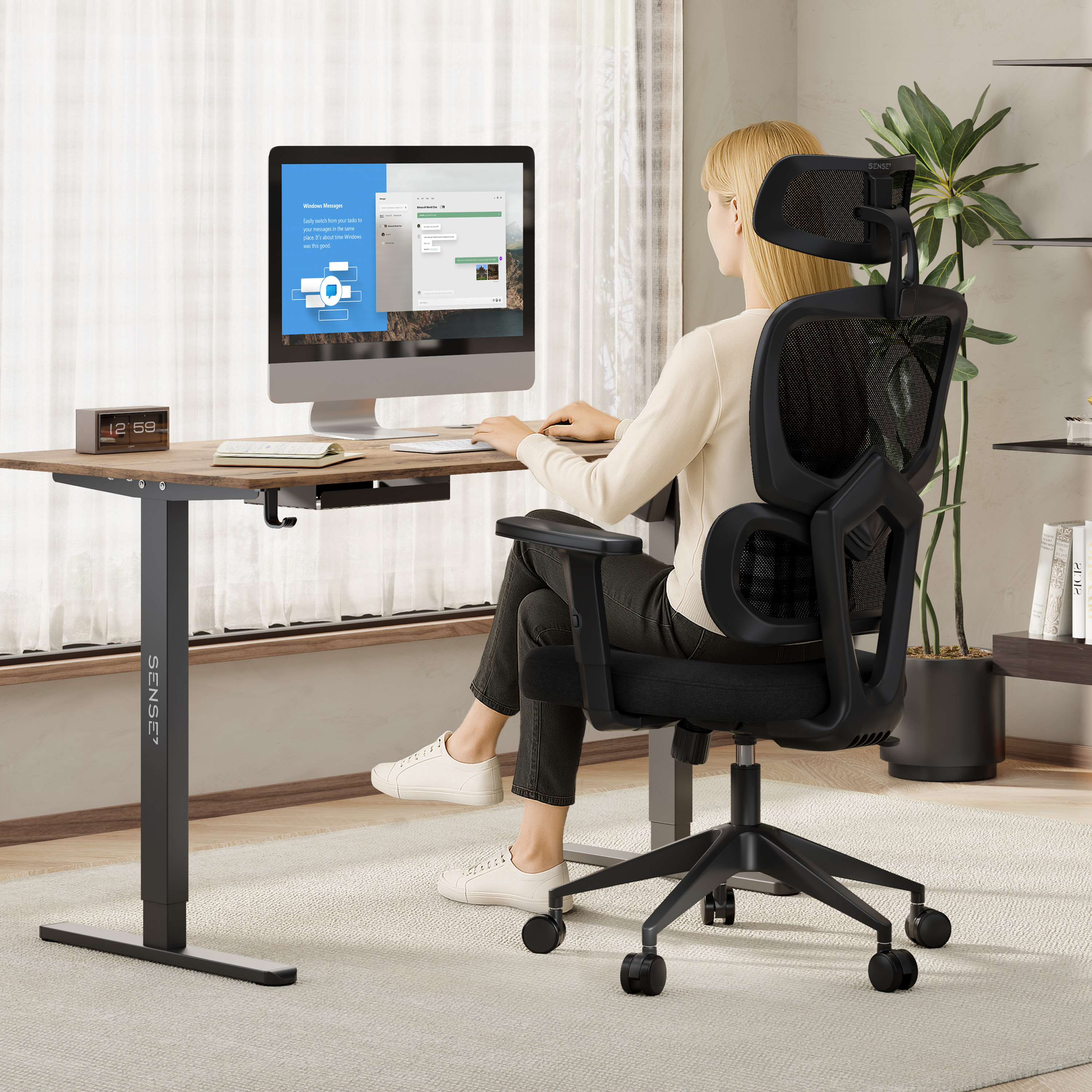 Donna alla scrivania che utilizza un computer con monitor. È seduta su una sedia ergonomica nera.