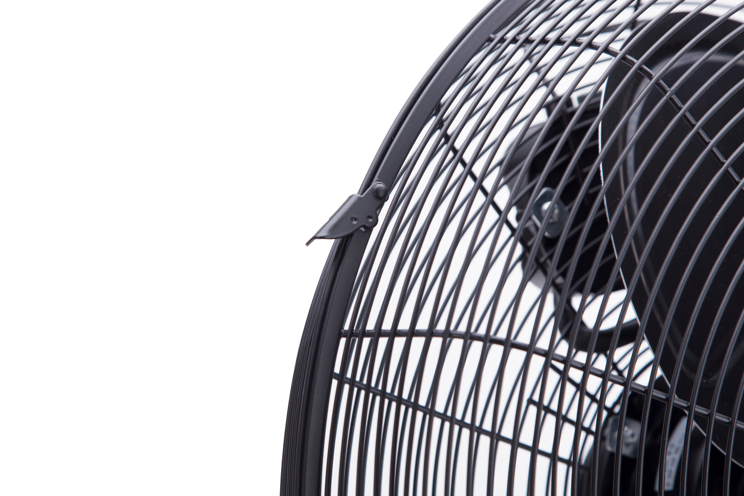 Primer plano de un ventilador negro, con rejilla metálica, sobre un fondo blanco.