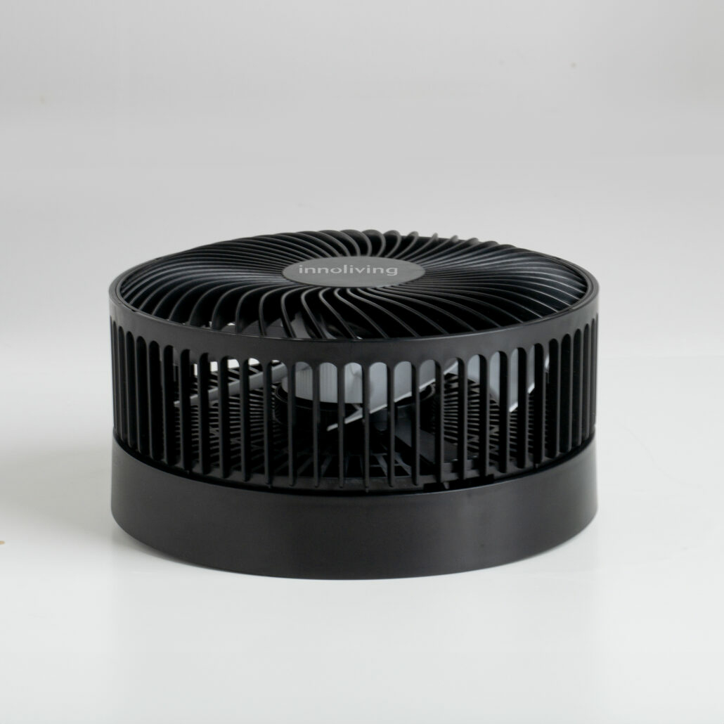 Ventilatore cilindrico nero con lamelle verticali e base nera. Sfondo bianco.