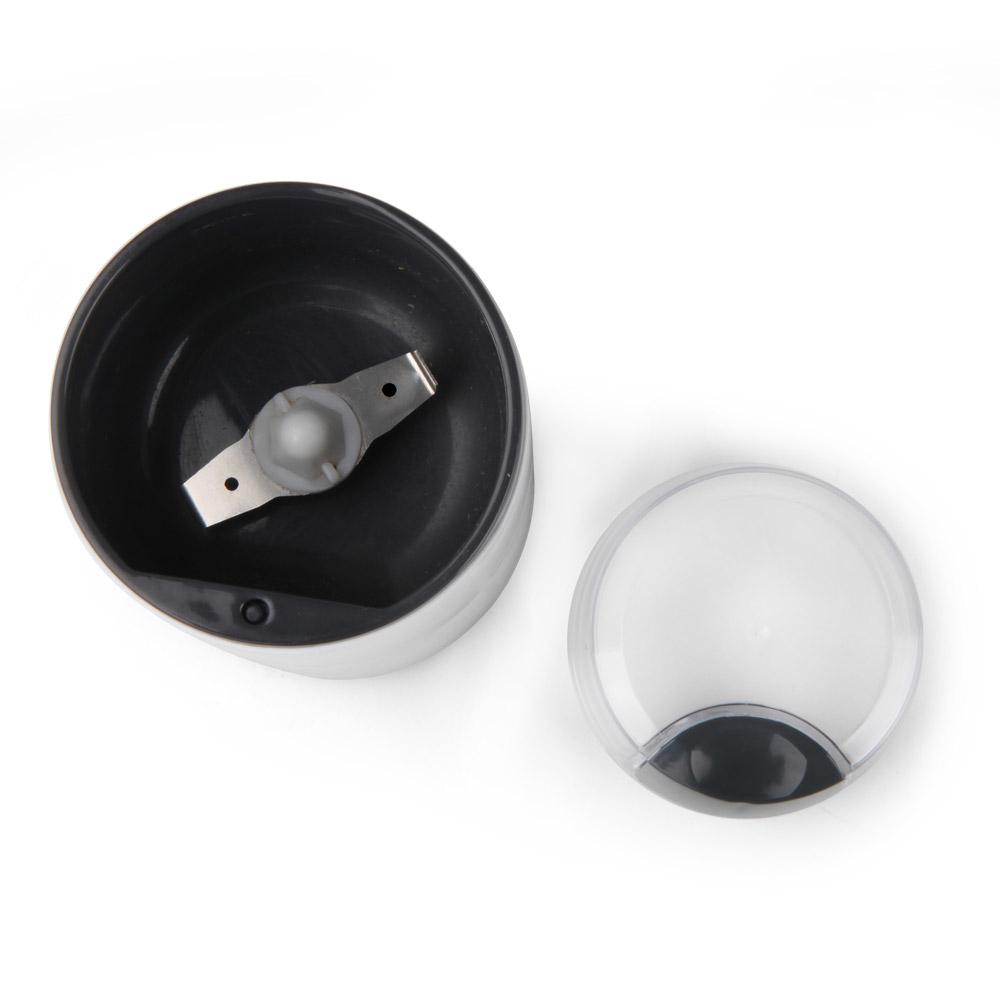 Młynek do kawy z widoczną pokrywą i ostrzem, na białym tle.