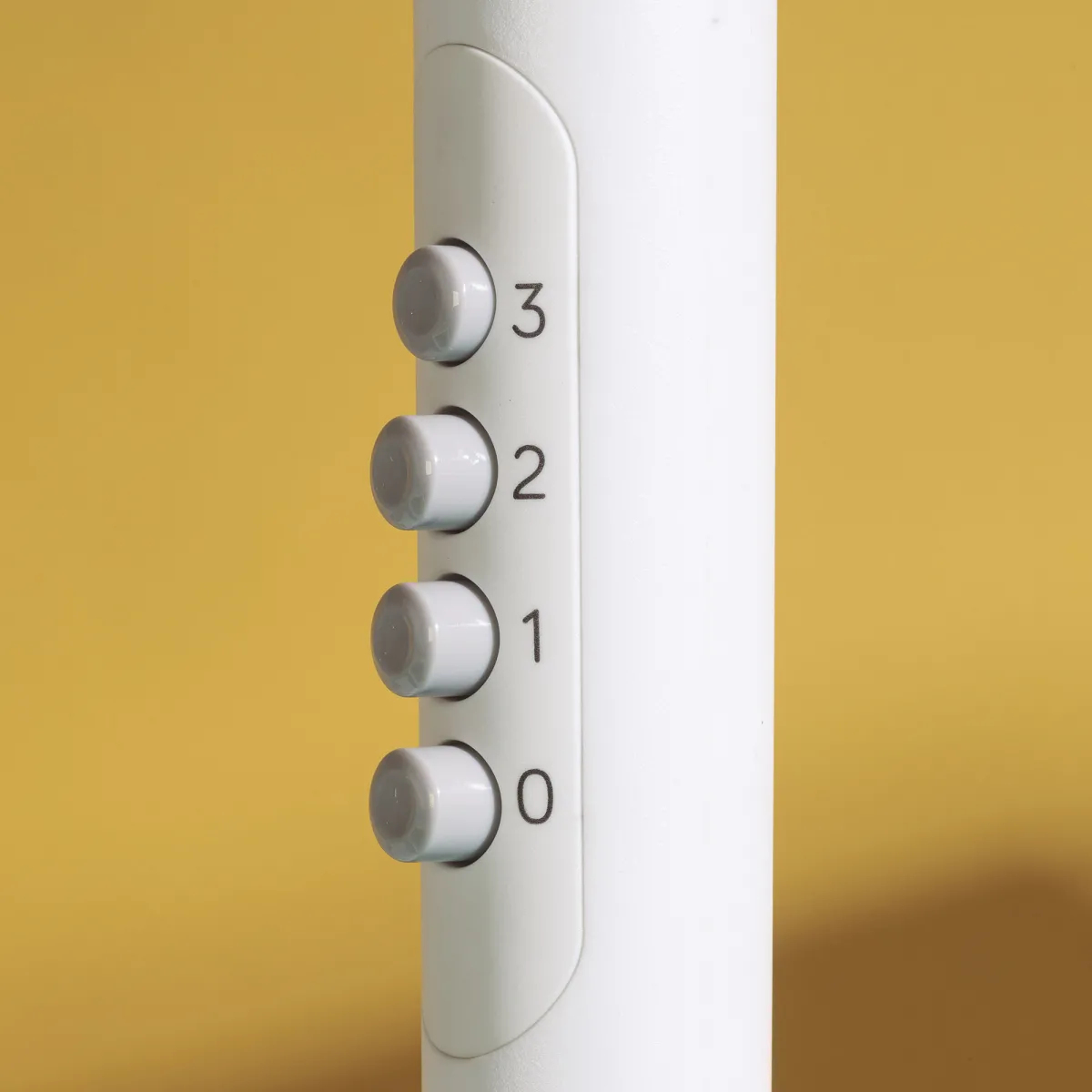 Primer plano de los botones de control del ventilador. Los botones están numerados del 0 al 3. Fondo amarillo.