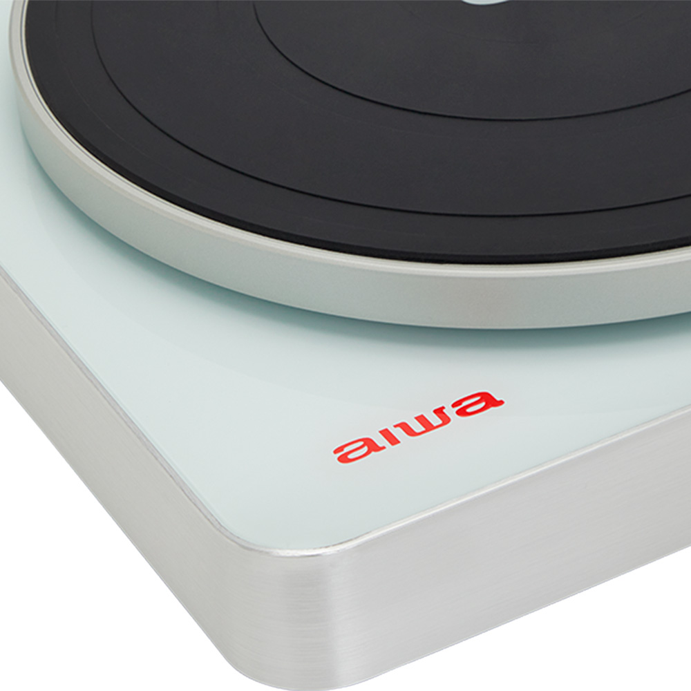 Primer plano de un tocadiscos blanco con el logotipo de Aiwa. Muestra la esquina y un disco negro.