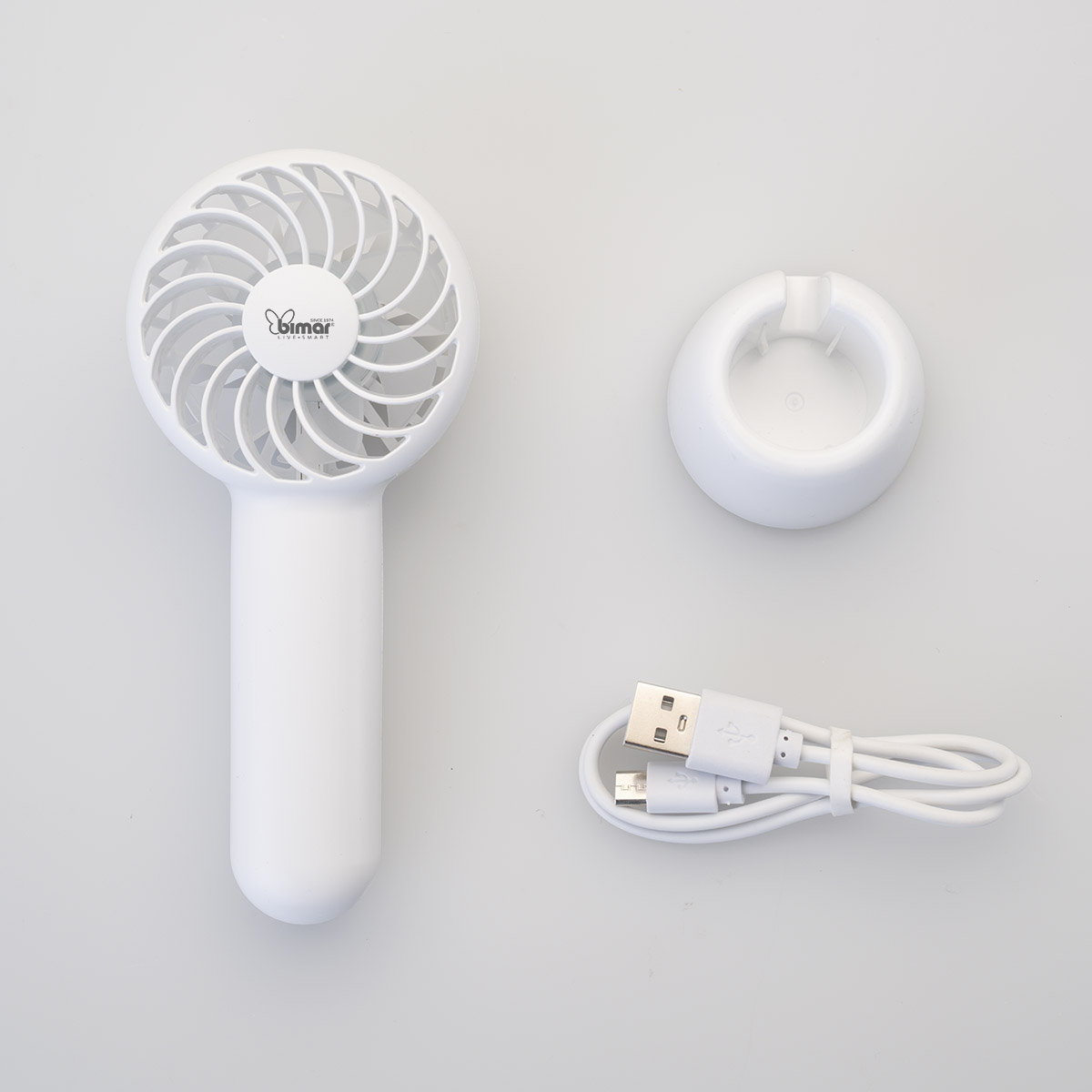 Een witte draagbare ventilator met een standaard en een oplaadkabel. De ventilator staat naast de standaard.