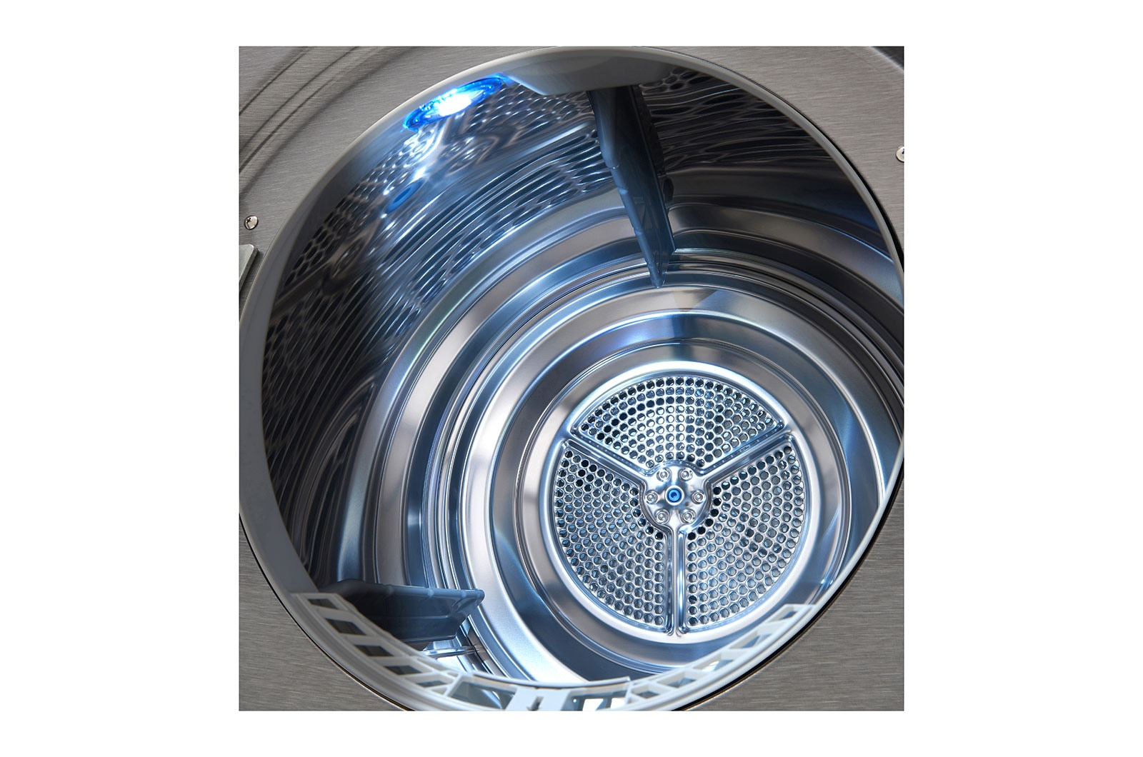 Wnętrze metalowego bębna suszarki. Świeci niebieskie światło.