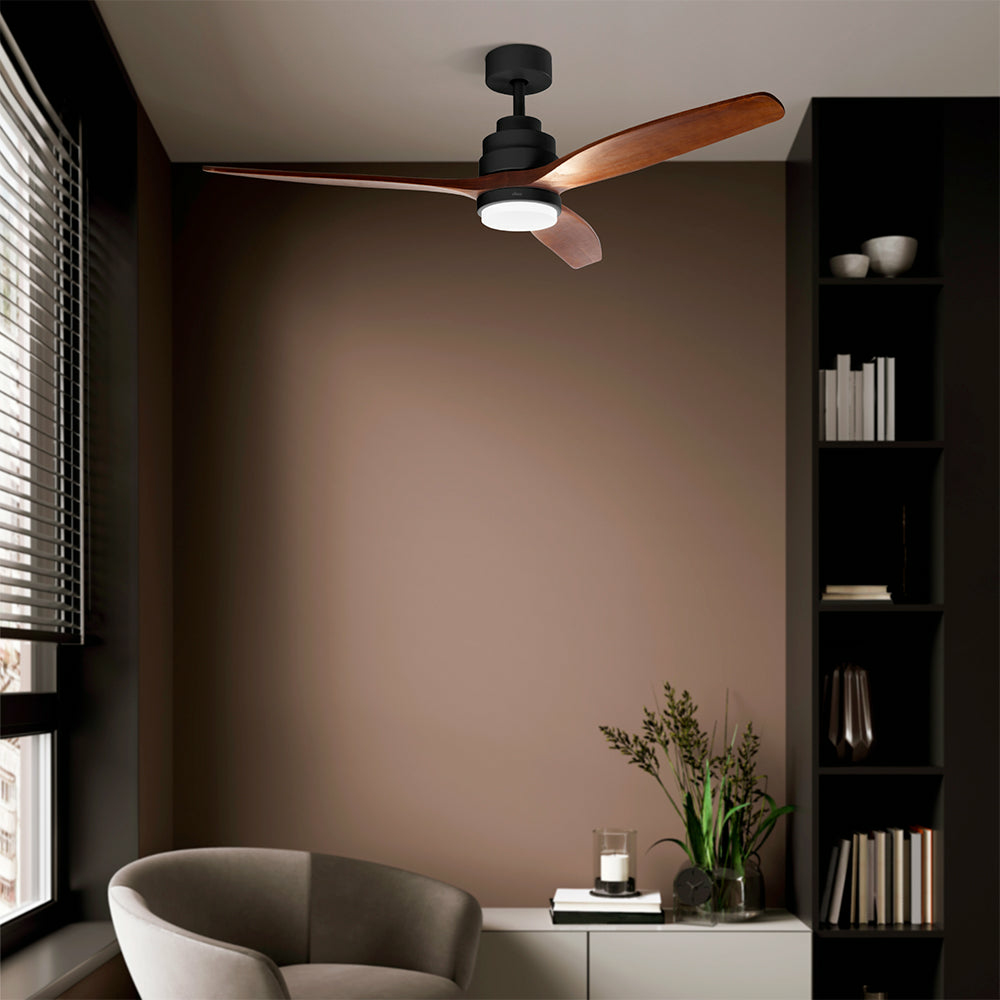 Ventilatore a soffitto con pale in legno in una stanza con parete marrone e mobile scuro.