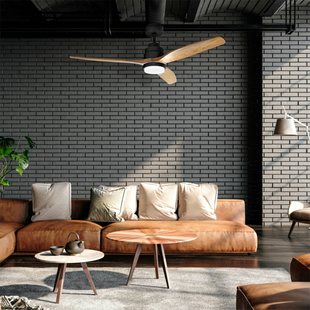 Wnętrze z wentylatorem sufitowym, brązową skórzaną sofą, małymi stolikami i ceglaną ścianą.