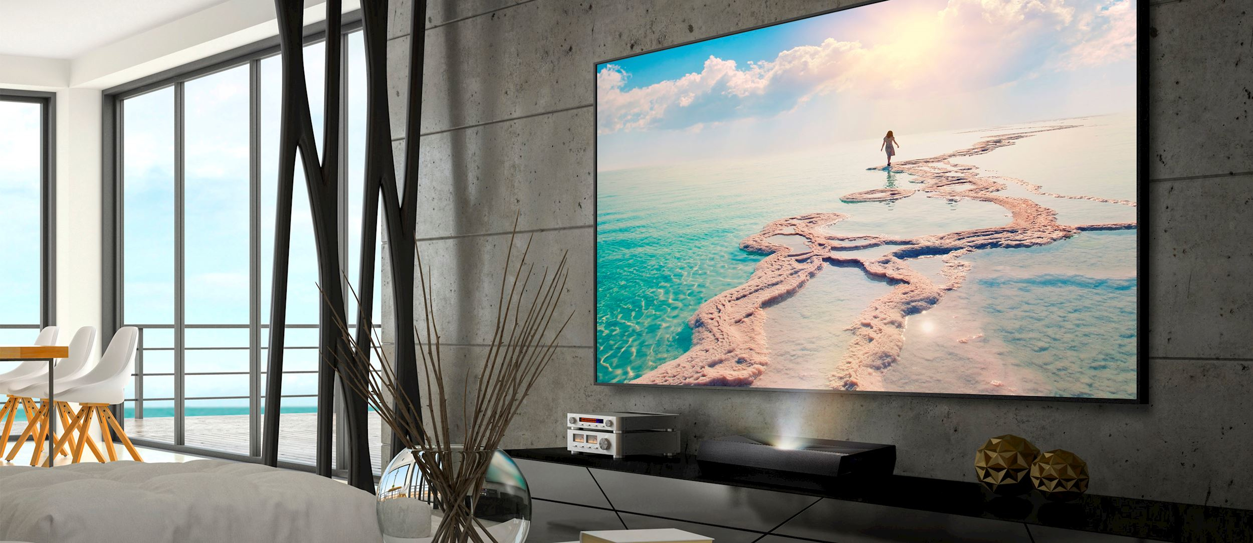 Una pantalla grande que muestra una escena de playa con una mujer, en una sala de estar moderna.