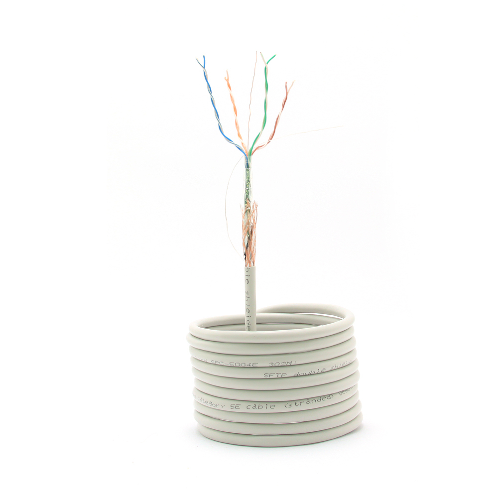 Zwinięty kabel z odsłoniętymi przewodami na górze. Szary kabel z tekstem. Białe tło.