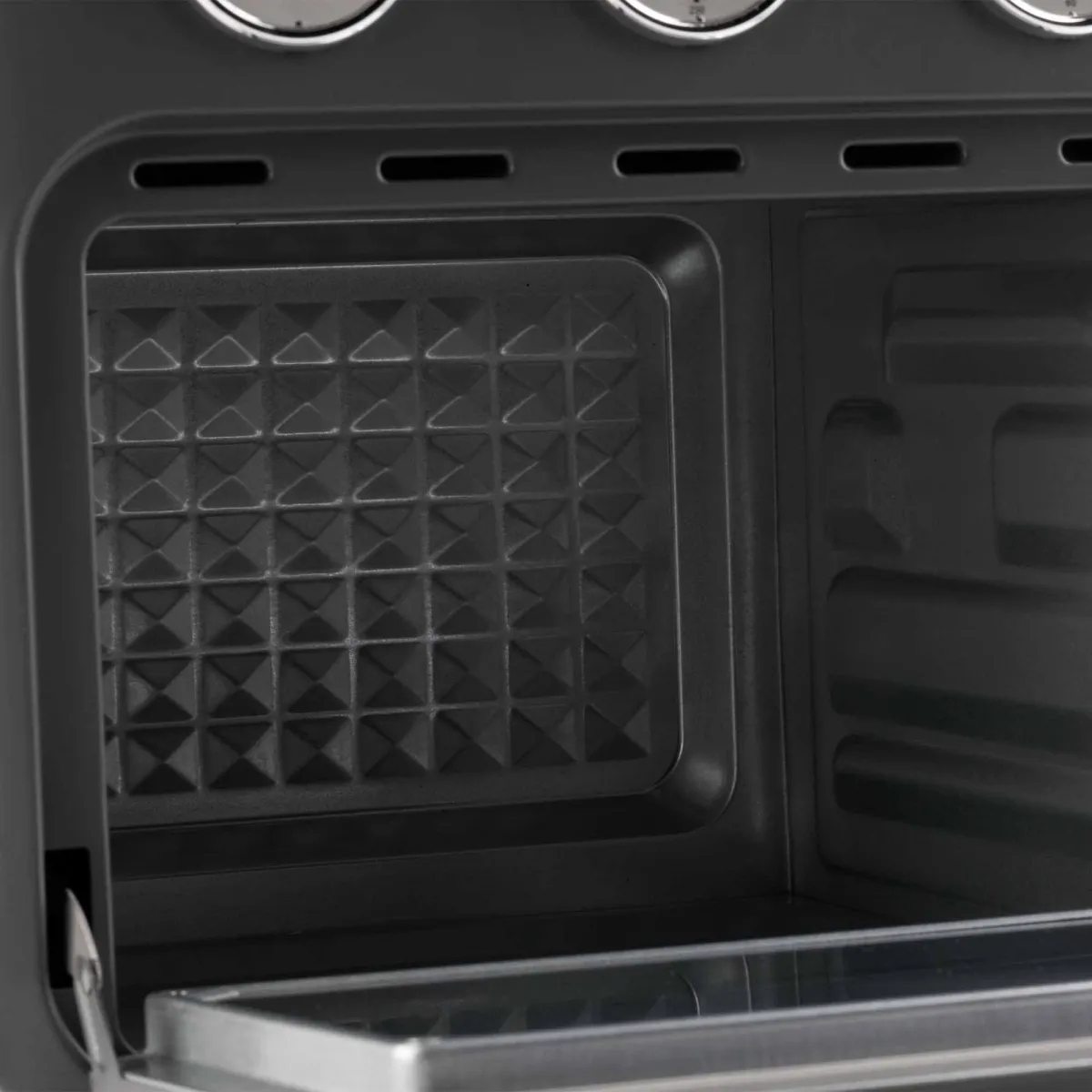 Primer plano del interior del horno. Gris oscuro, con fondo estampado y bandeja metálica.