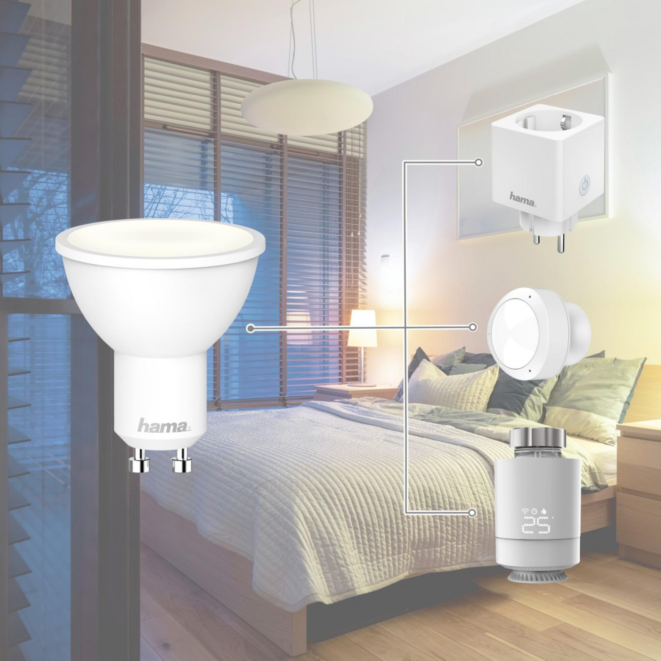 Scena di camera da letto con una lampadina LED Hama, una presa intelligente e un termostato. Tutto collegato a un sistema smart home.