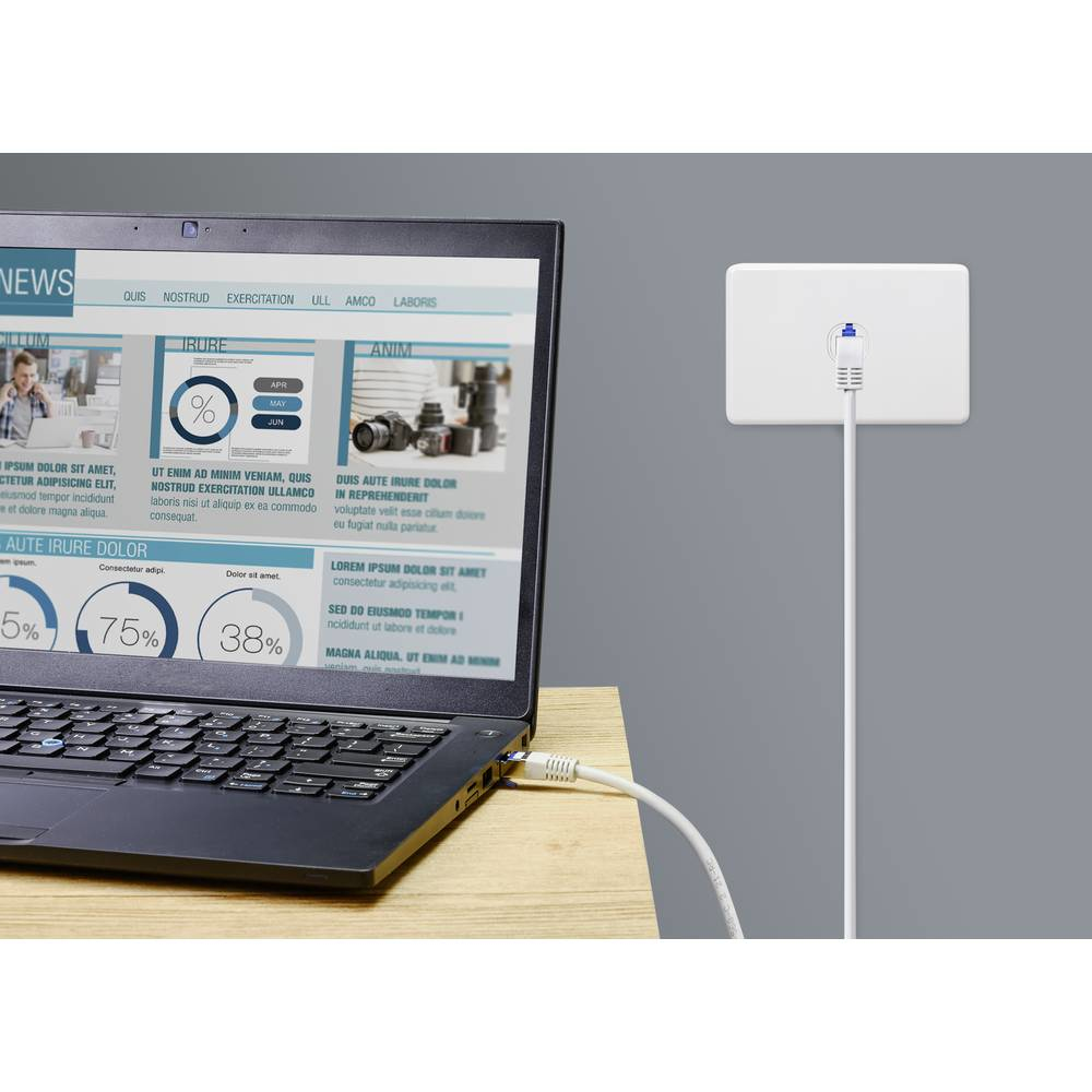Un laptop collegato a una presa a muro tramite un cavo bianco. Sito web di notizie visualizzato.