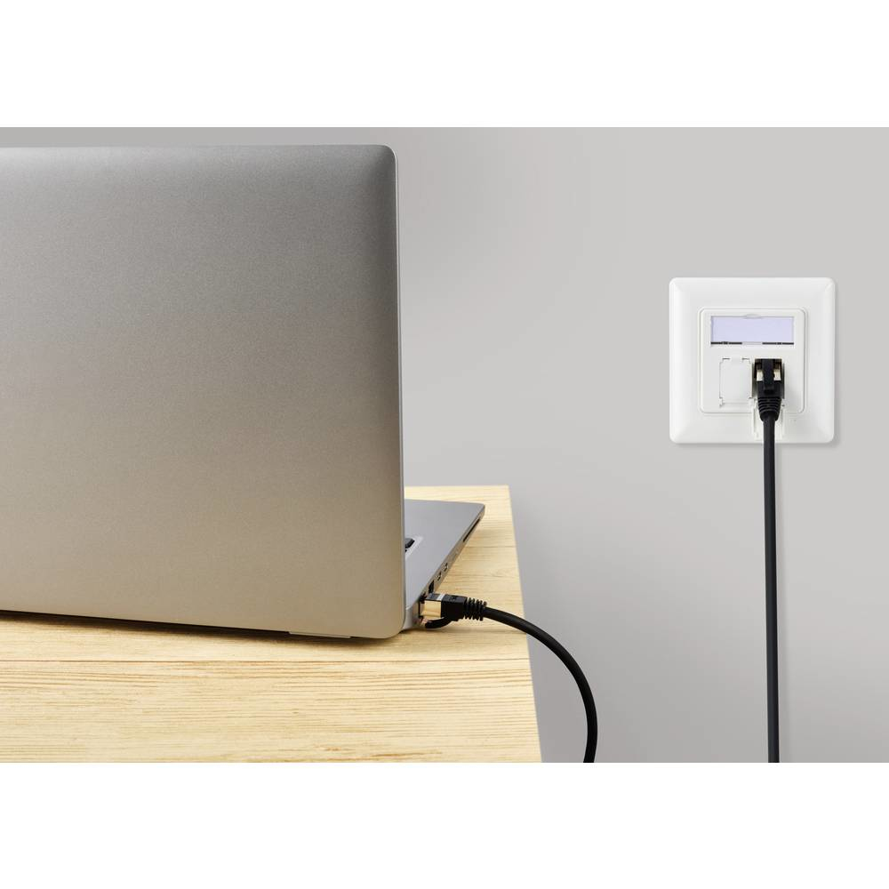 Un laptop è collegato a una presa a muro tramite un cavo di rete nero. La presa è bianca.