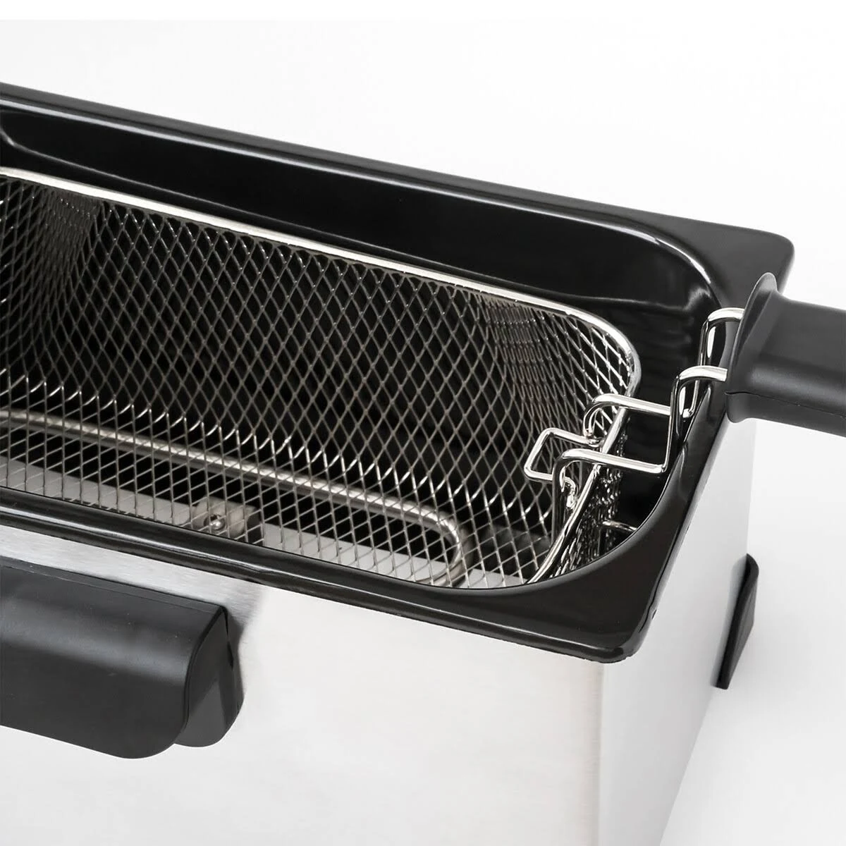Primer plano de una cesta de freír dentro de una freidora de acero inoxidable.
