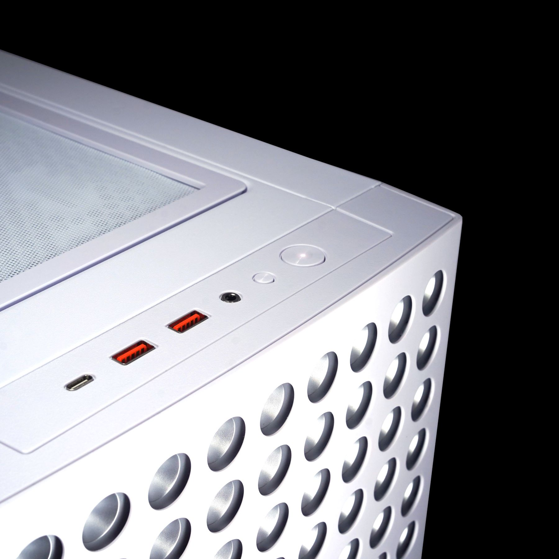 Ecke eines silbernen Computergehäuses mit Lüftungslöchern, Ein-Aus-Taste und USB-Anschlüssen.