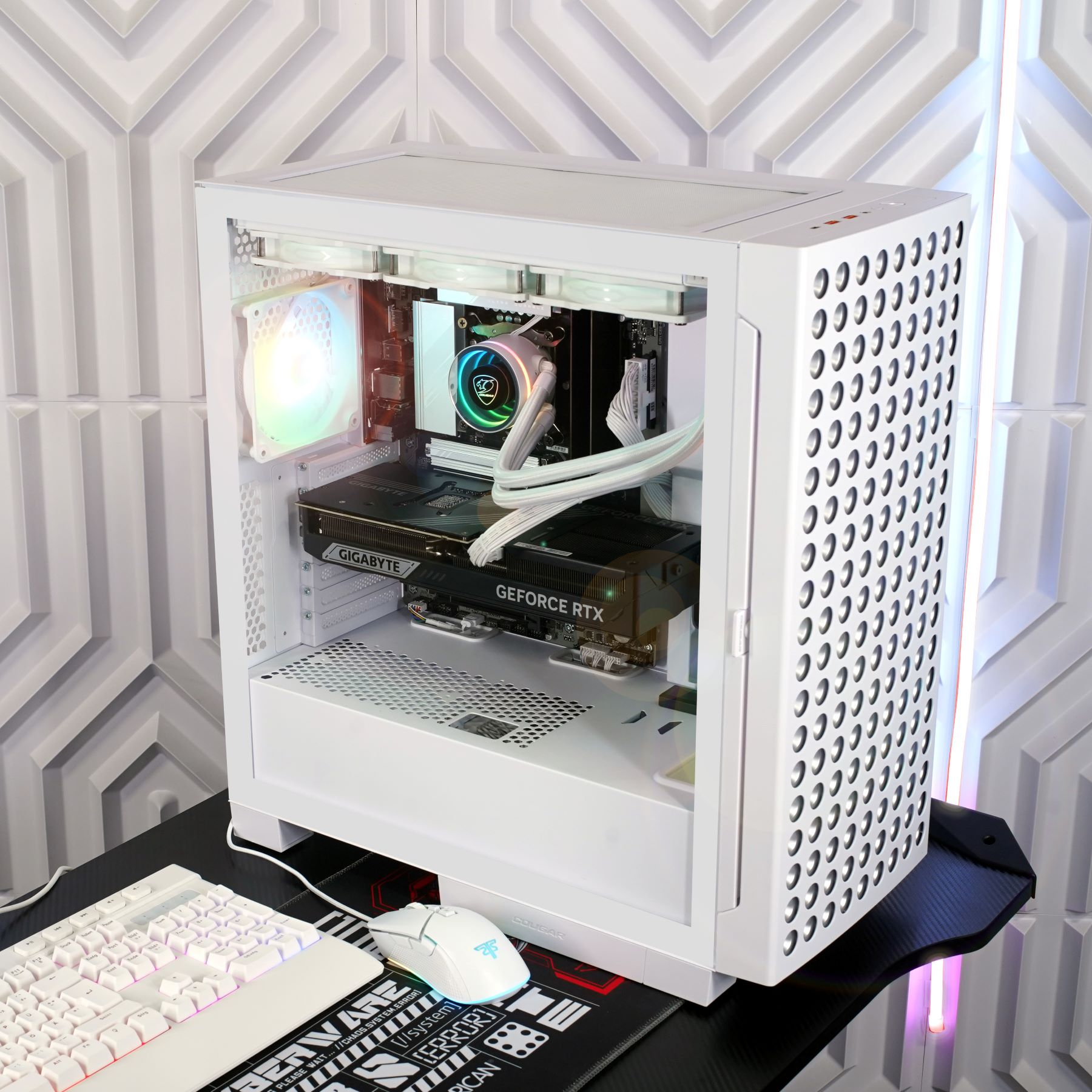 Weißes Computergehäuse mit sichtbaren Komponenten, Tastatur, Maus und schwarzer Schreibtischmatte.