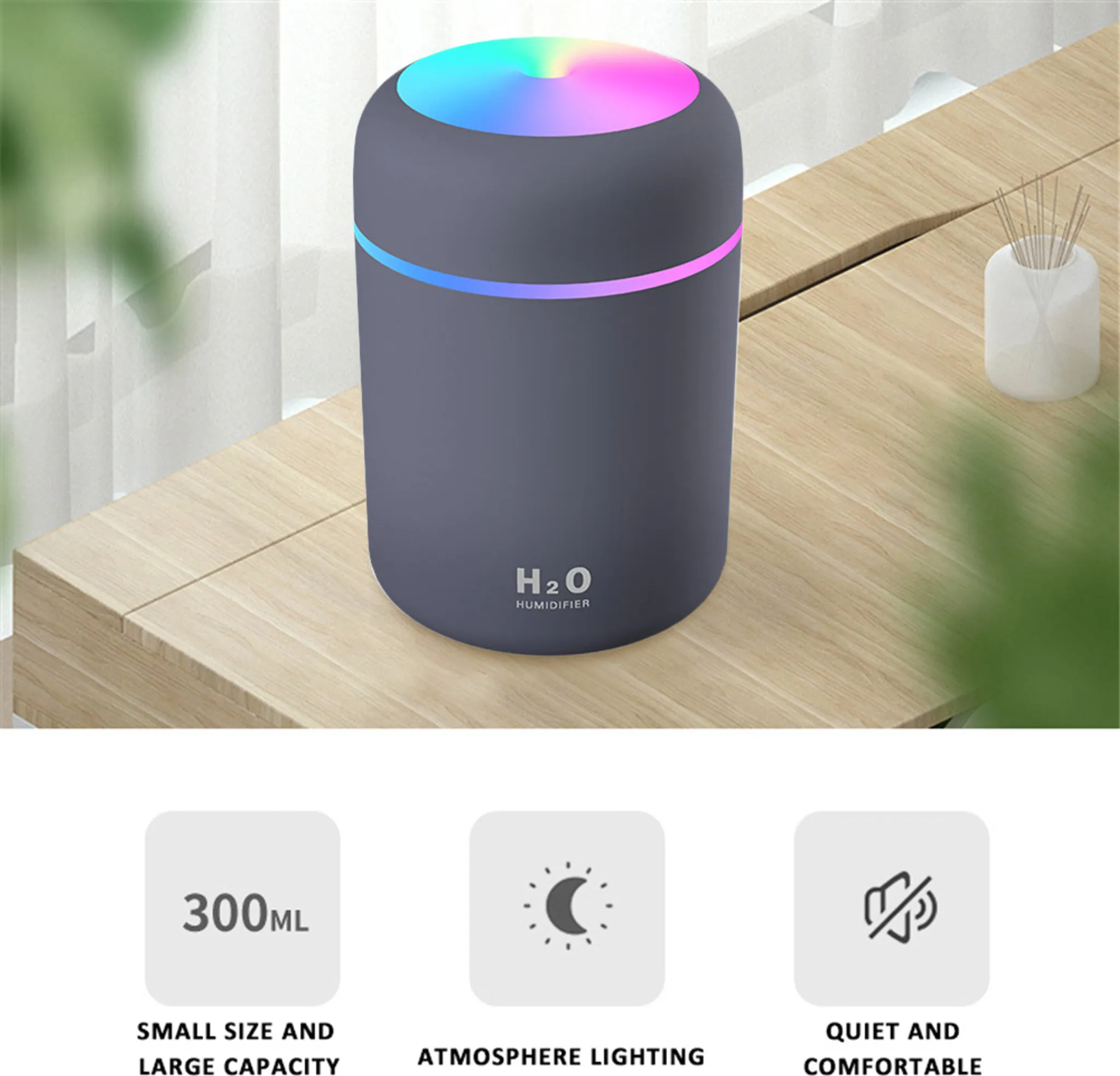 Ein grauer Luftbefeuchter mit farbigem Lichtring. Er steht auf einer Holzoberfläche. Text: 'H2O Luftbefeuchter'.