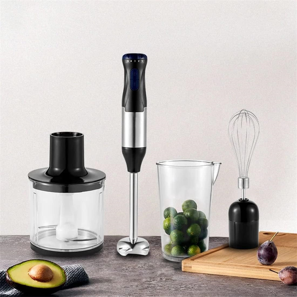Ein Mixerset mit Motoreinheit, Zerkleinerungsbehälter, Krug mit Limetten und Schneebesen.
