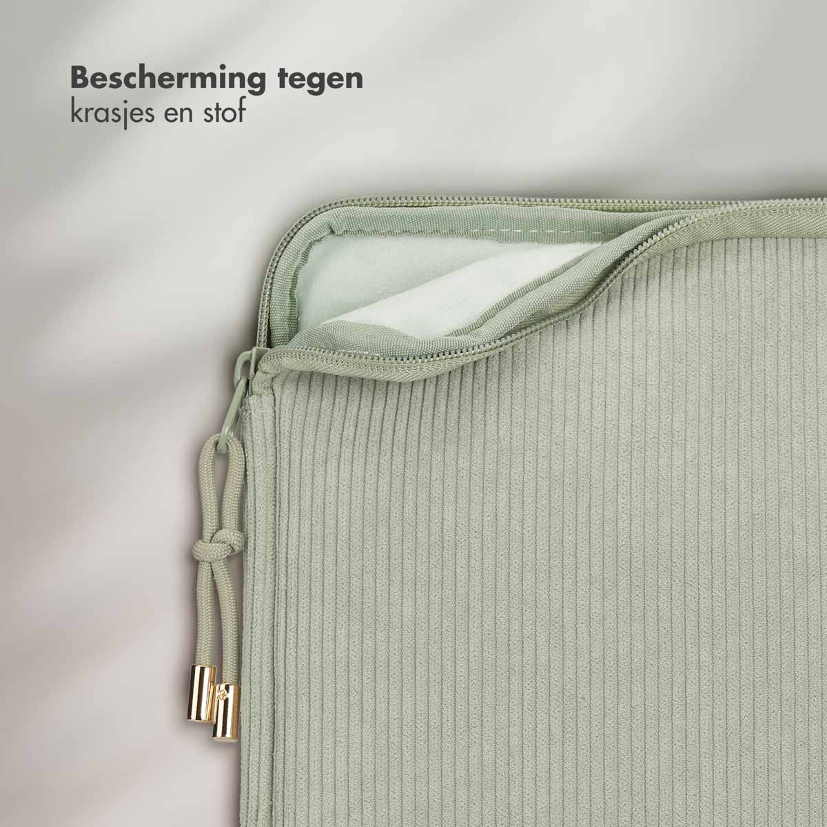 A light green laptop sleeve with a zipper and gold-colored details, close-up.