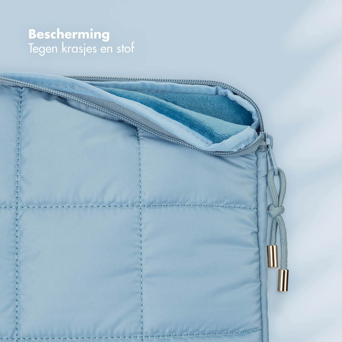 Blauwe gewatteerde beschermhoes met rits, voor een laptop of tablet.