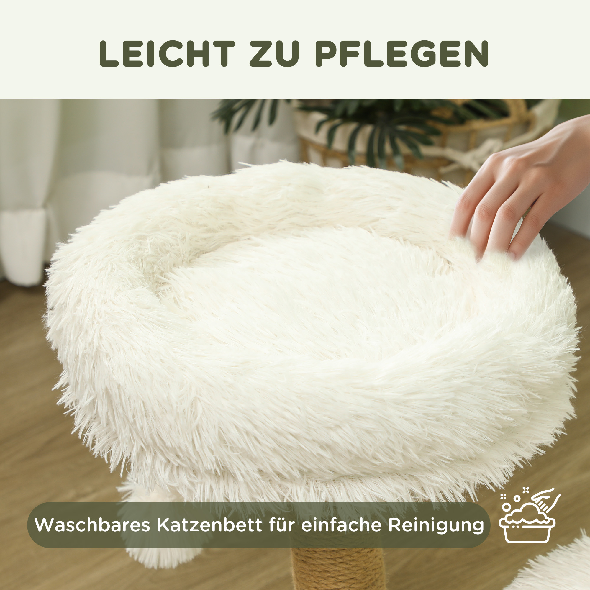 Ein weißes, flauschiges Katzenbett auf einem Ständer. Die Hand einer Person berührt das Bett.