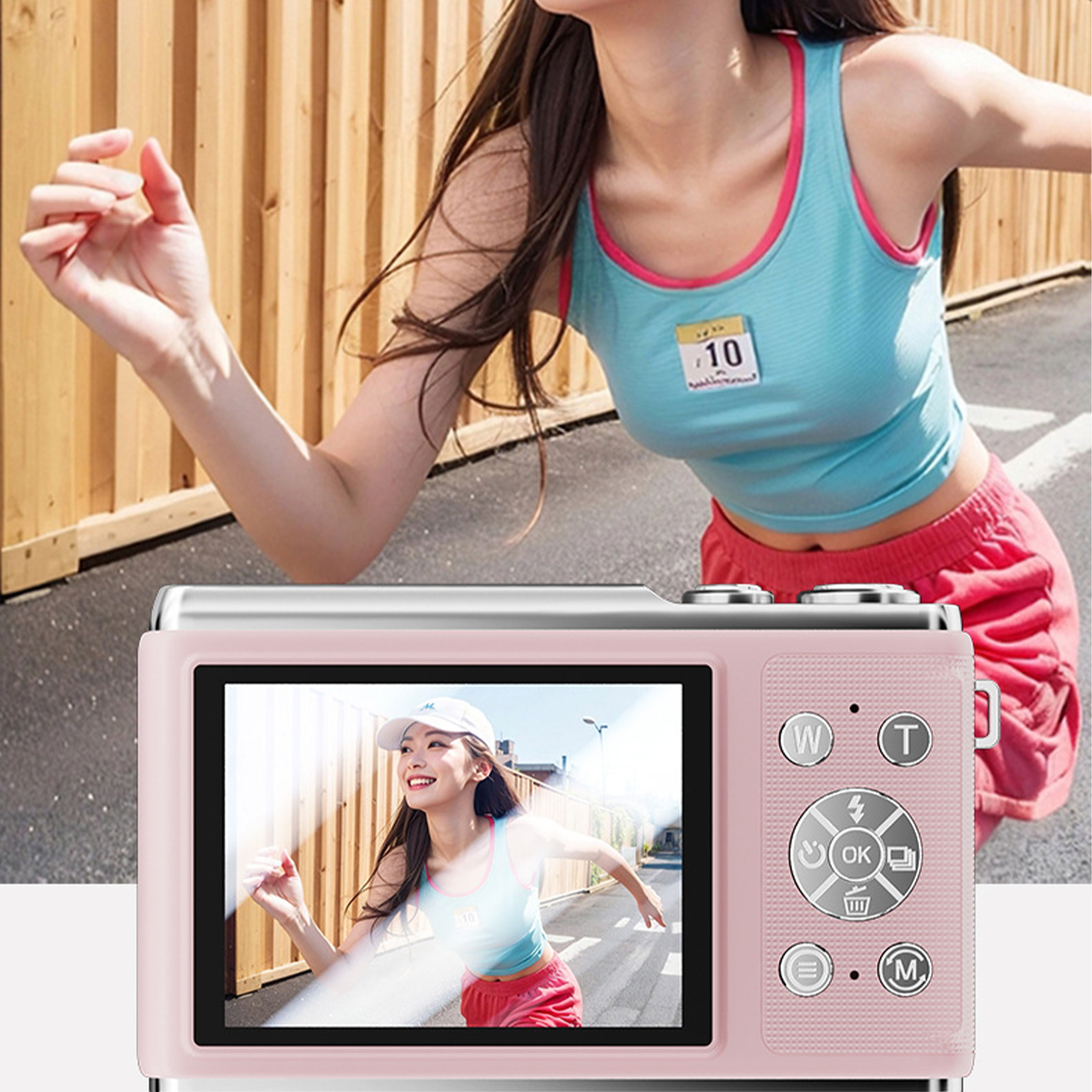Eine rosa Digitalkamera mit einem Bildschirm, der eine laufende Frau zeigt. Eine Frau hält eine Kamera.
