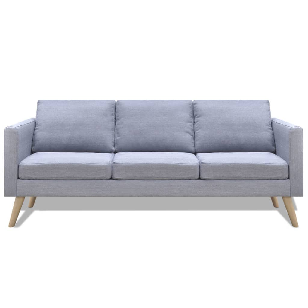 Ein graues Sofa mit drei Kissen und Holzbeinen. Es steht vor weißem Hintergrund.