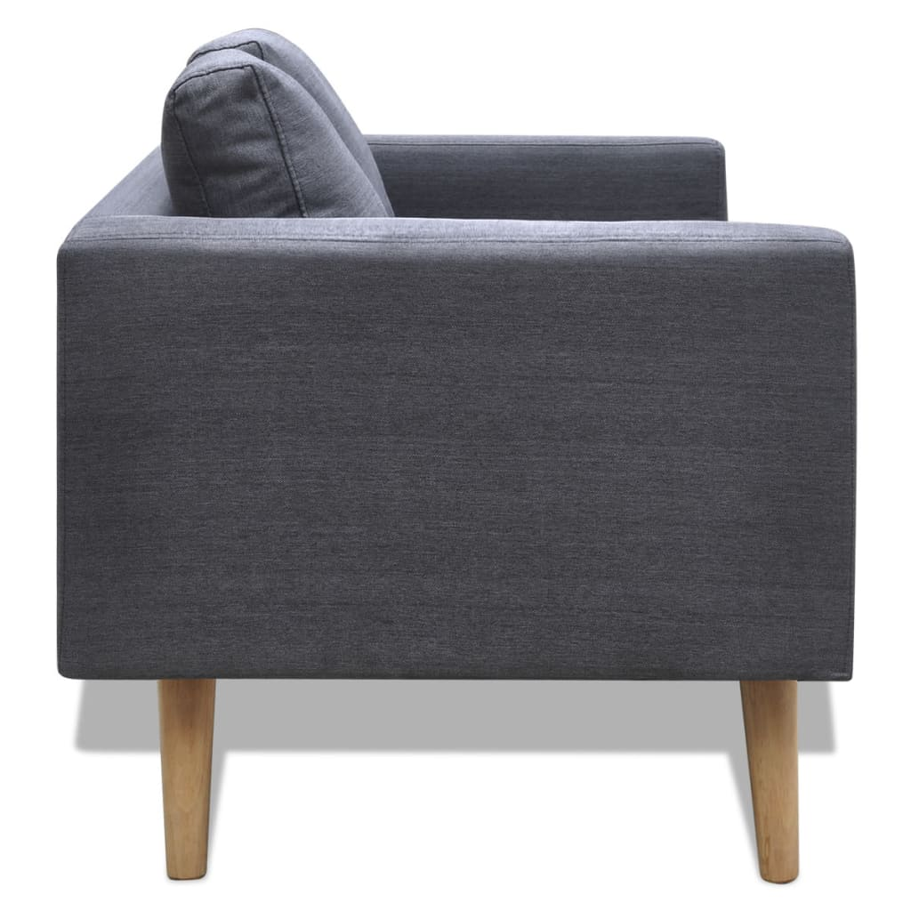 Ein dunkelgraues Sofa mit grauem Kissen, auf Holzbeinen, vor weißem Hintergrund.