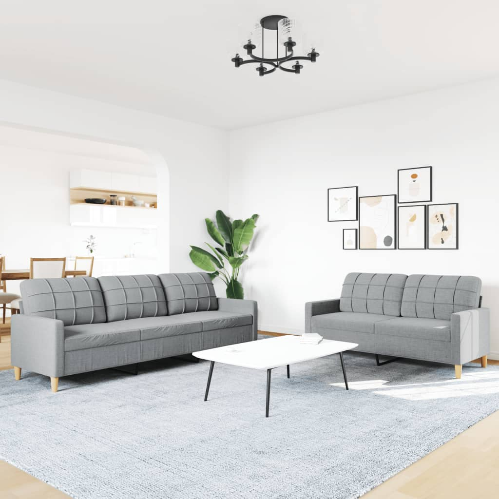 Ein Wohnzimmer mit grauen Sofas, einem weißen Couchtisch und einem Kronleuchter.