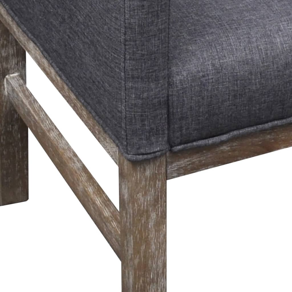 Nahaufnahme eines grauen Stoffstuhls mit Holzbeinen. Der Stoff ist strukturiert.
