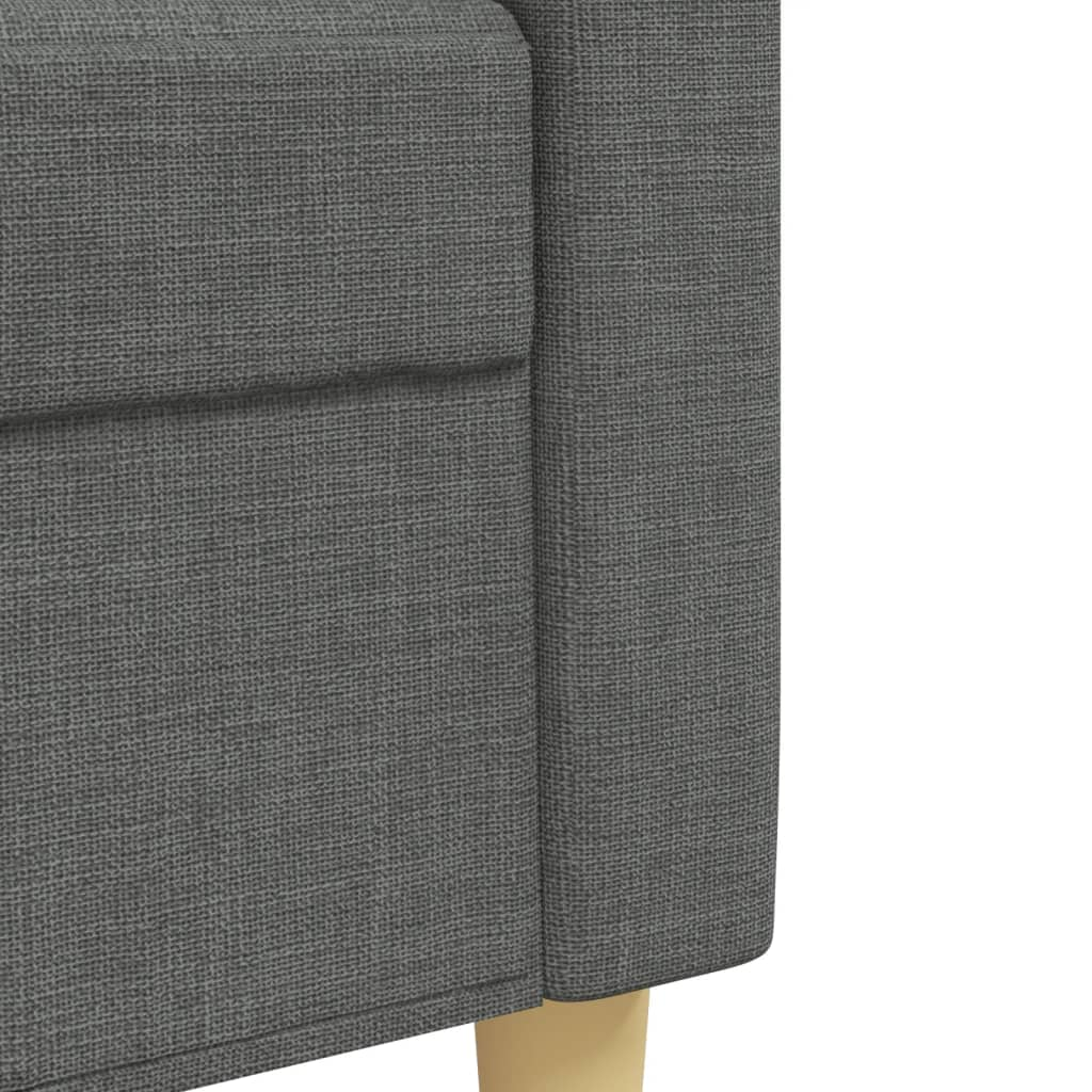 Nahaufnahme eines grauen Sofarmarms. Der Stoff ist strukturiert, die Beine sind helles Holz.