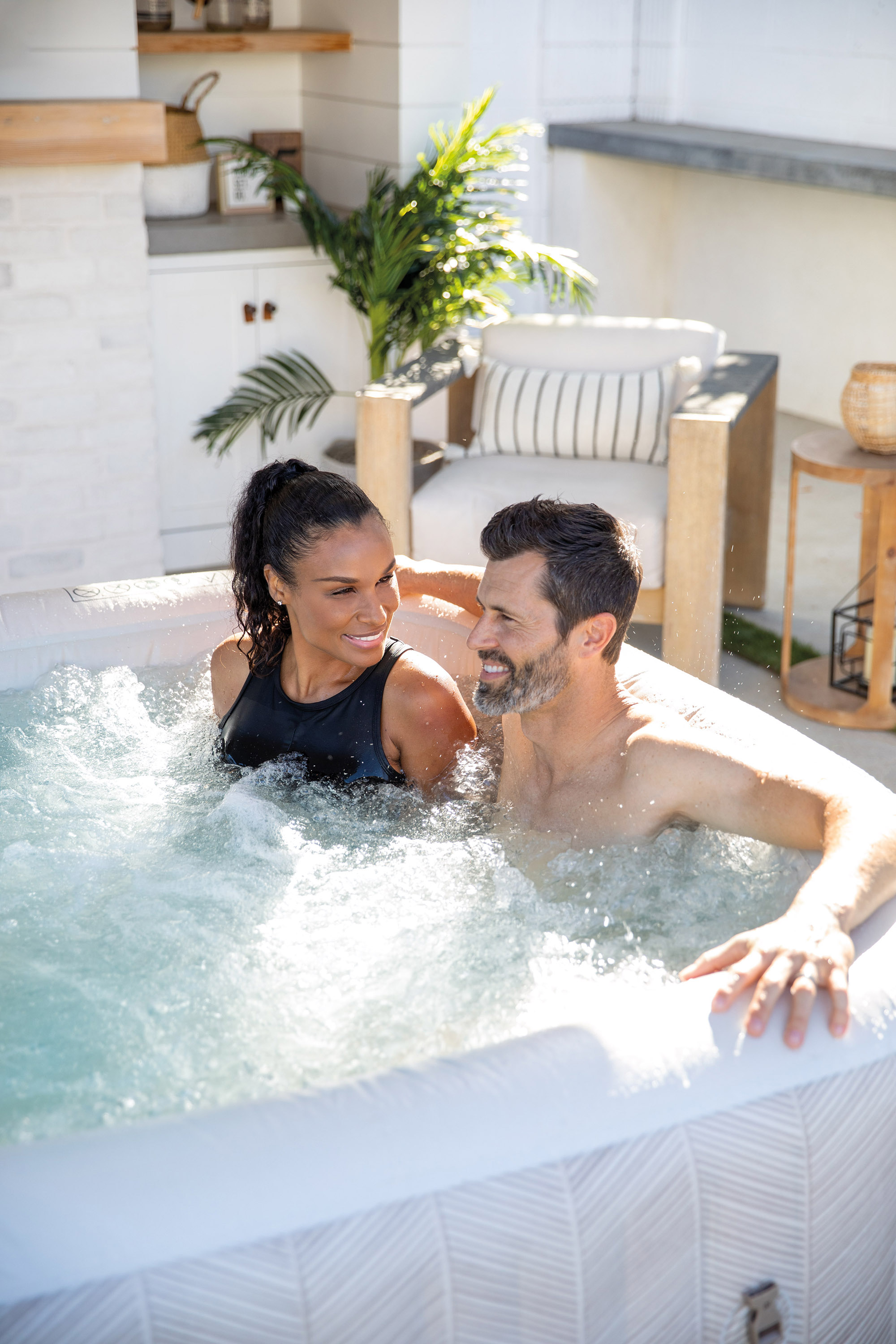 Ein Paar sitzt in einem Whirlpool und genießt das Wasser und die Sonne.