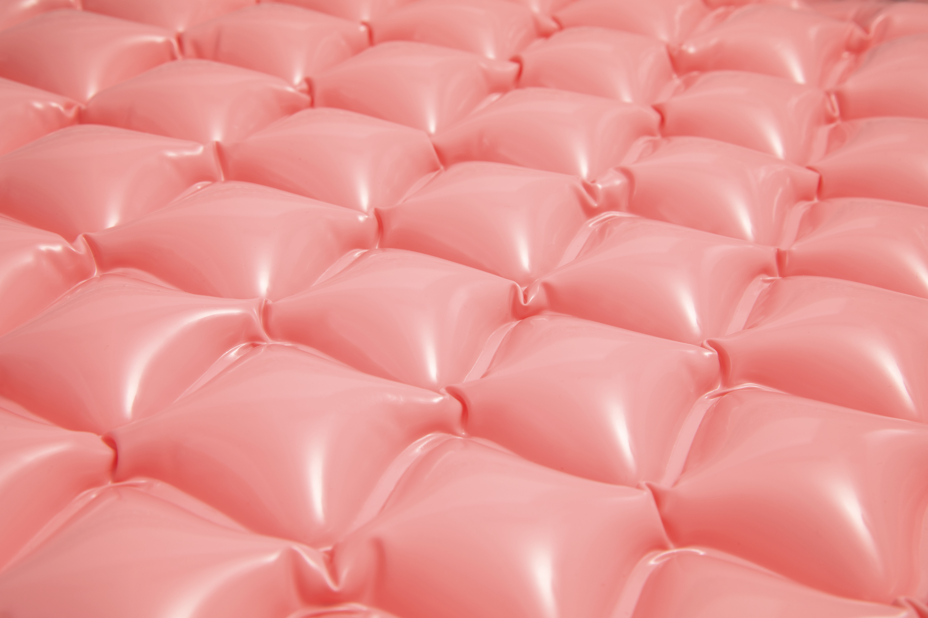 Różowa, teksturowana, nadmuchiwana powierzchnia materaca, widok z bliska.