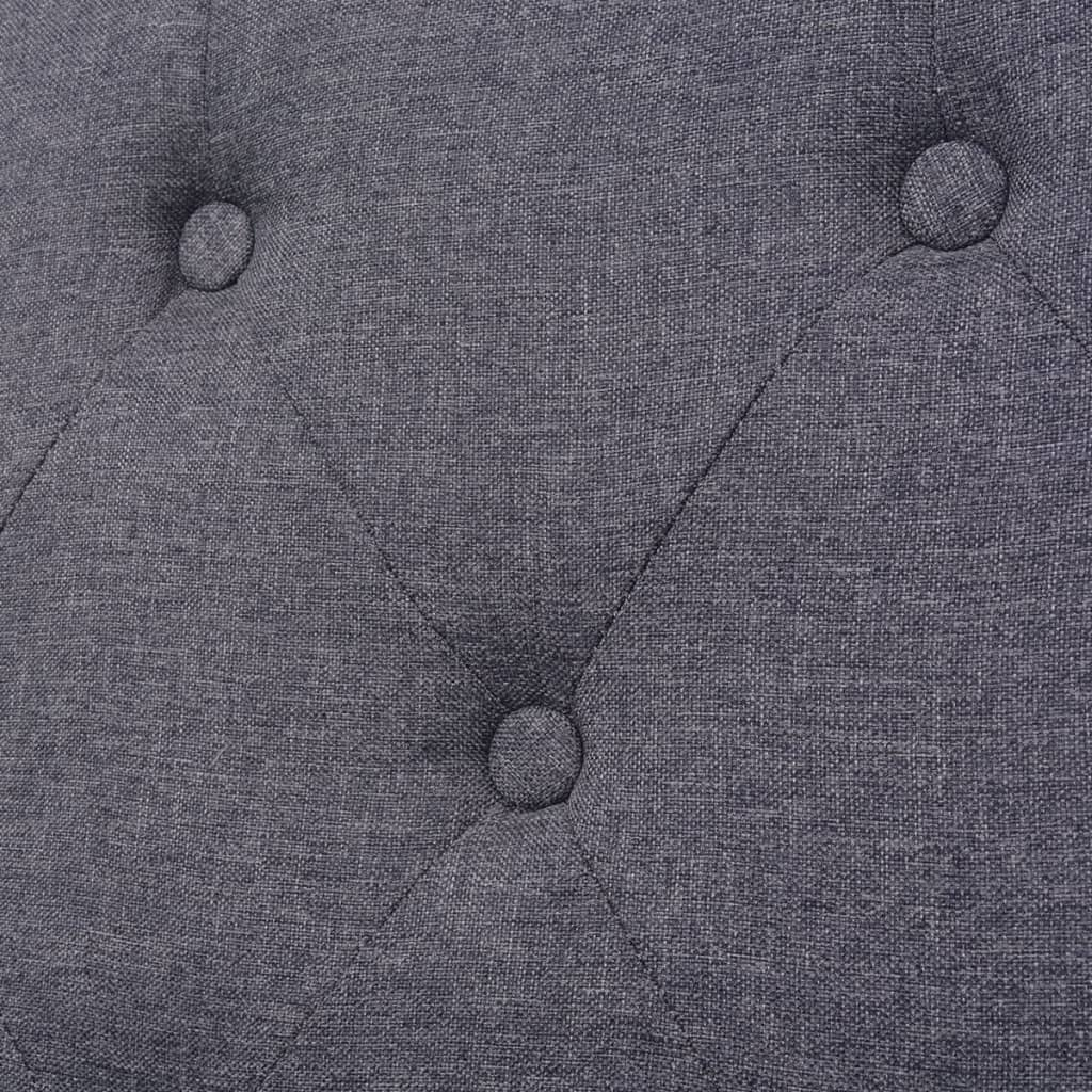 Nahaufnahme eines grauen Stoffes mit Knopfdetails. Sichtbare Knöpfe und gestepptes Rastermuster.