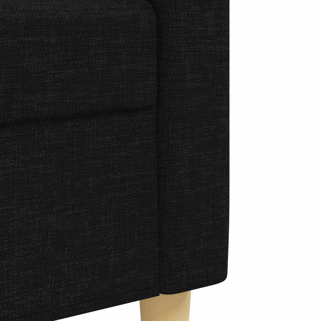 Nahaufnahme des schwarzen Stoffes an der Seite eines Sofas mit hellen Holzbeinen.