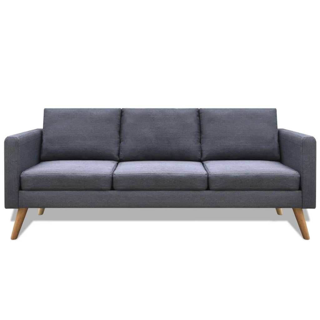 Ein dunkelgraues Sofa mit drei Kissen und Holzbeinen. Es steht vor weißem Hintergrund.