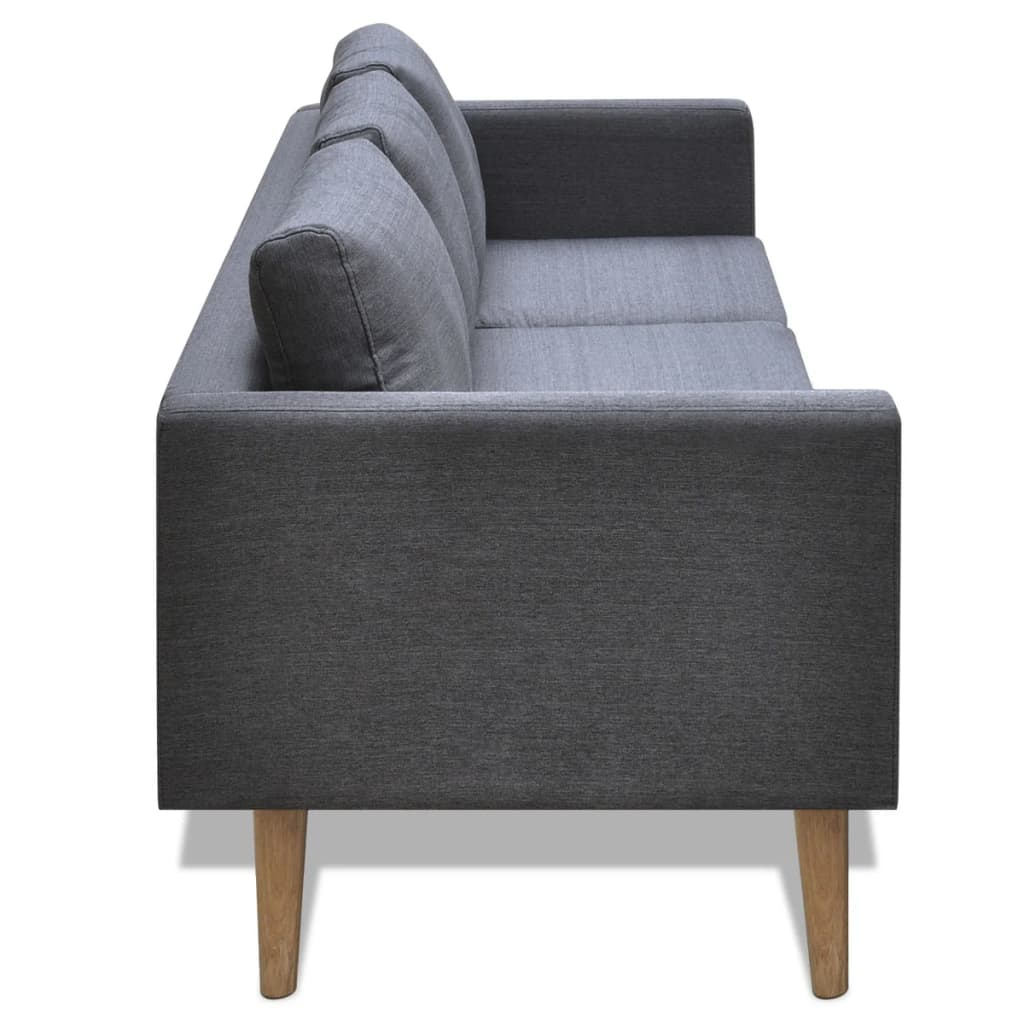 Ein graues Sofa mit Holzbeinen und hellgrauen Kissen.