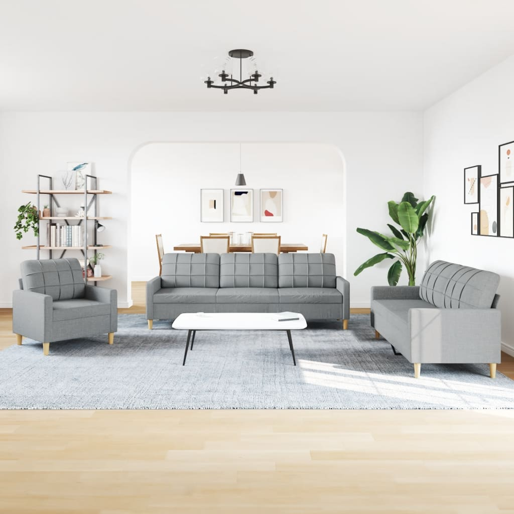Wohnzimmer mit grauer Sofagarnitur, einem Teppich und einem Couchtisch. Kunstwerke und ein Kronleuchter vorhanden.