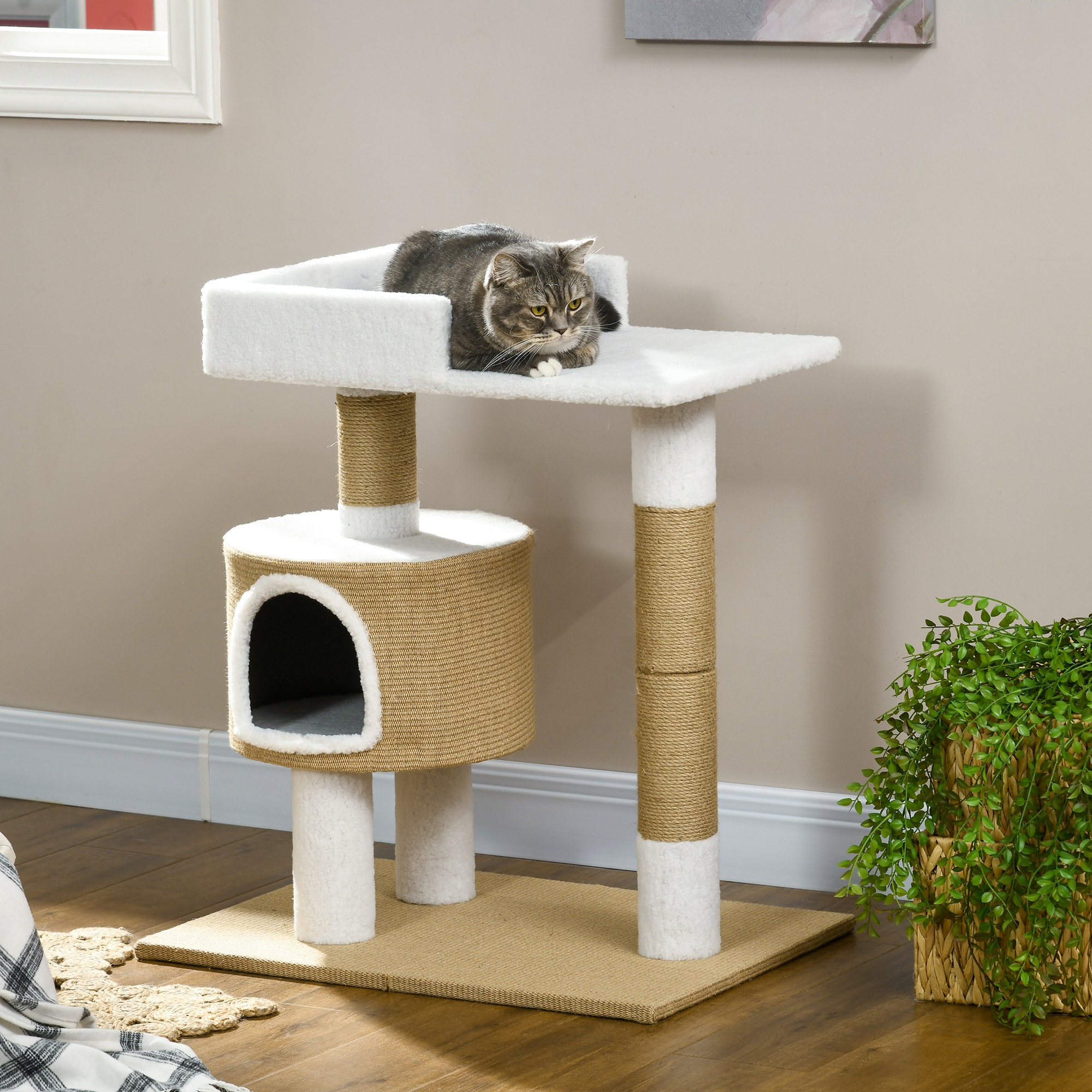 Kratzbaum mit Katze oben. Beige- und Weißtöne, mit Kratzpfosten.