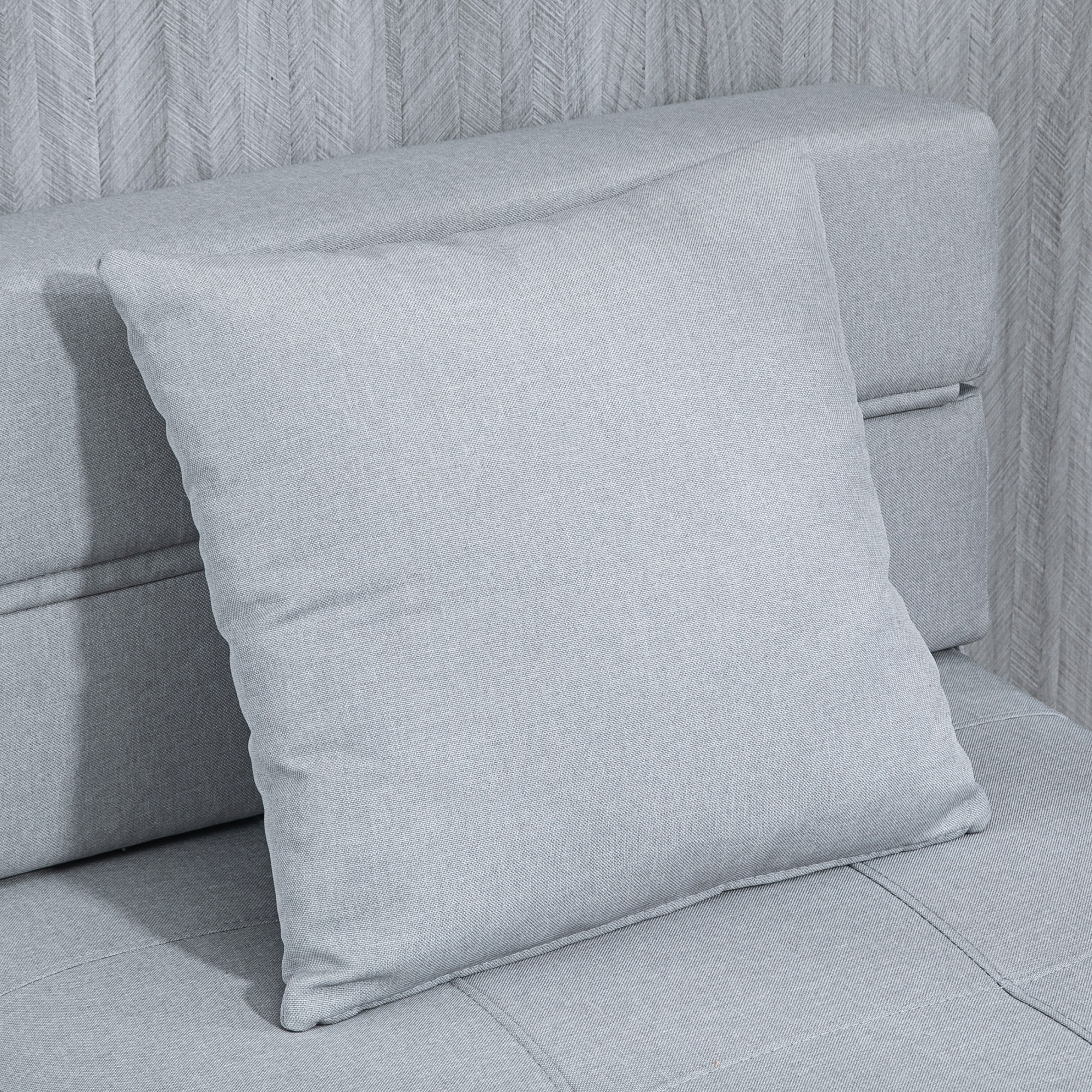 Graues Kissen auf einem grauen Sofa, Nahaufnahme.