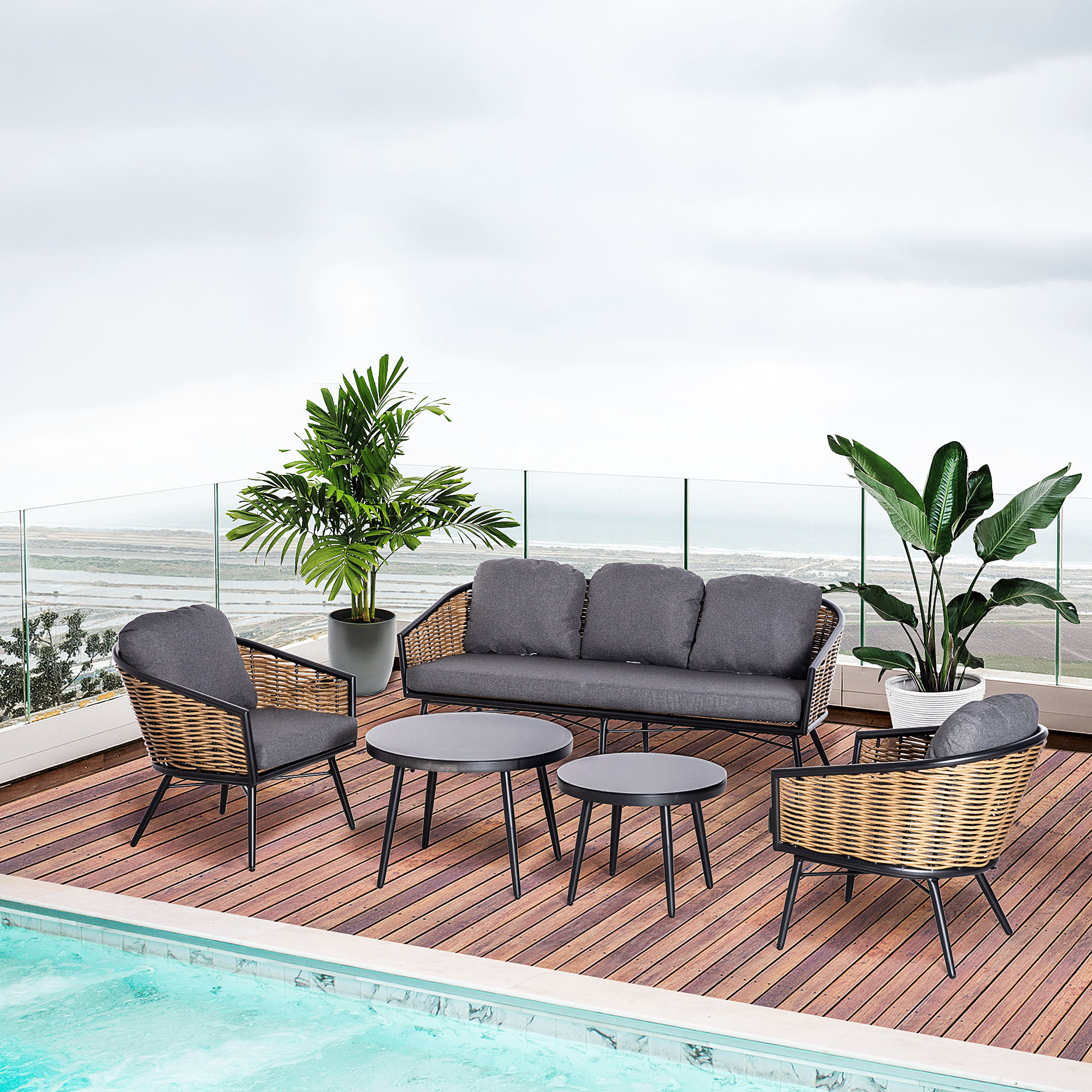 Gartenmöbel-Set auf einer Terrasse, einschließlich Sofa, Stühlen und Tisch.