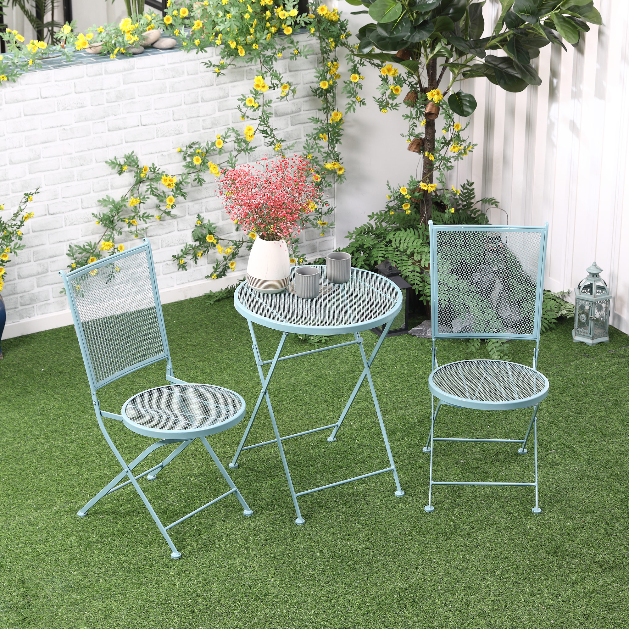 Ein hellblaues Bistro-Set im Freien auf einem grünen Rasen.