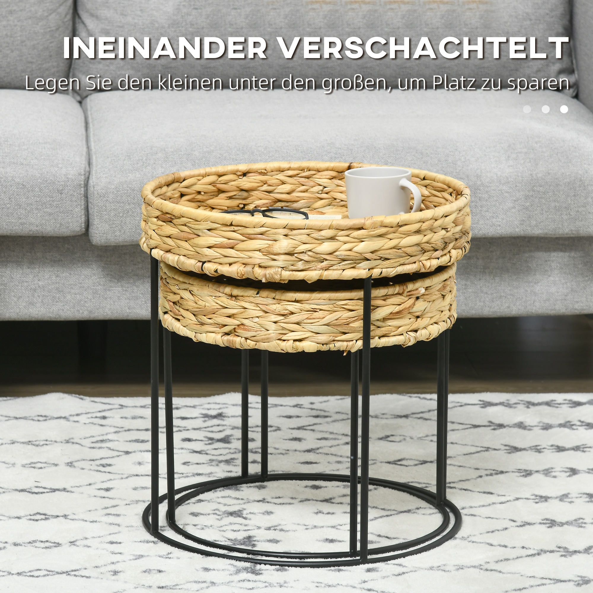 Zweistufiger Beistelltisch aus geflochtenem Korb mit schwarzen Metallbeinen. Oben stehen eine Tasse und Gläser.