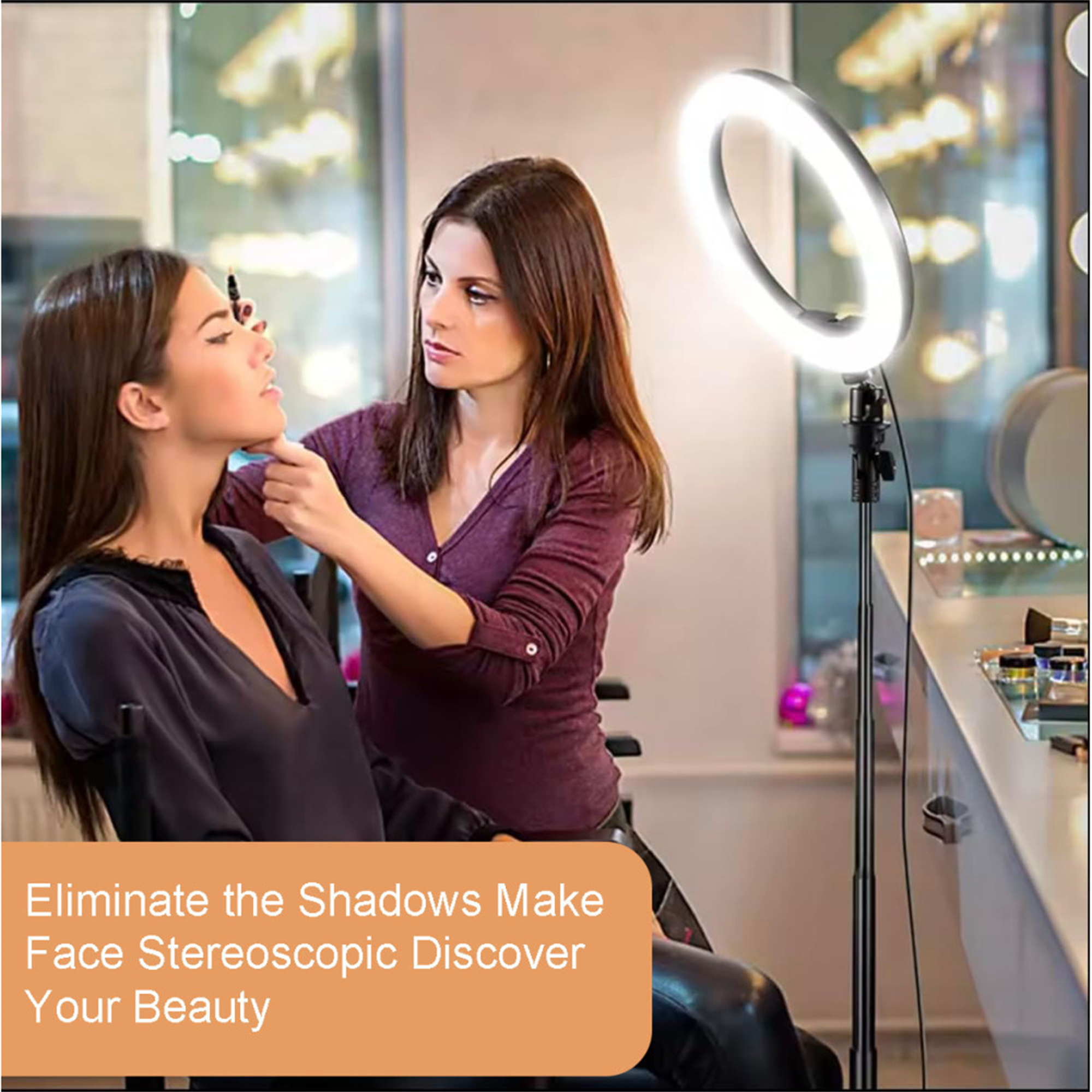 Einer Frau wird unter einem Ringlicht Make-up aufgetragen. Eine zweite Frau trägt das Make-up auf.