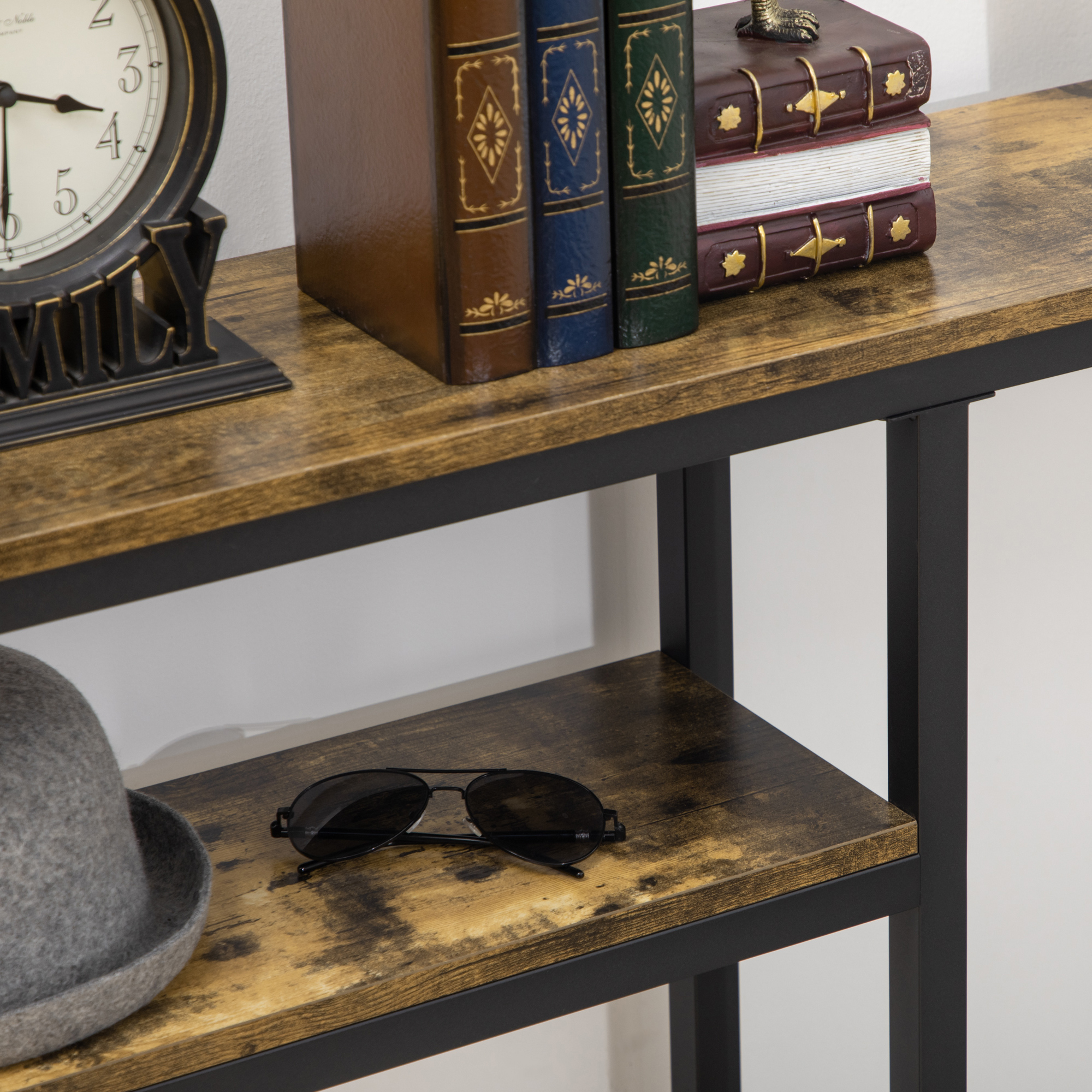 Ein Regal mit Büchern, einer Uhr und Sonnenbrillen. Das Regal besteht aus Holz und Metall.
