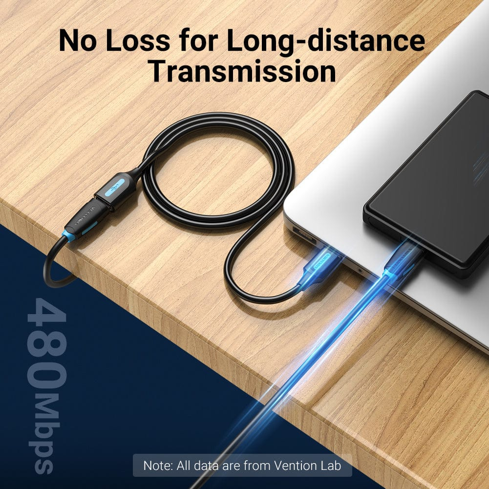 Een USB-kabel is aangesloten op een laptop en een apparaat op een houten oppervlak.