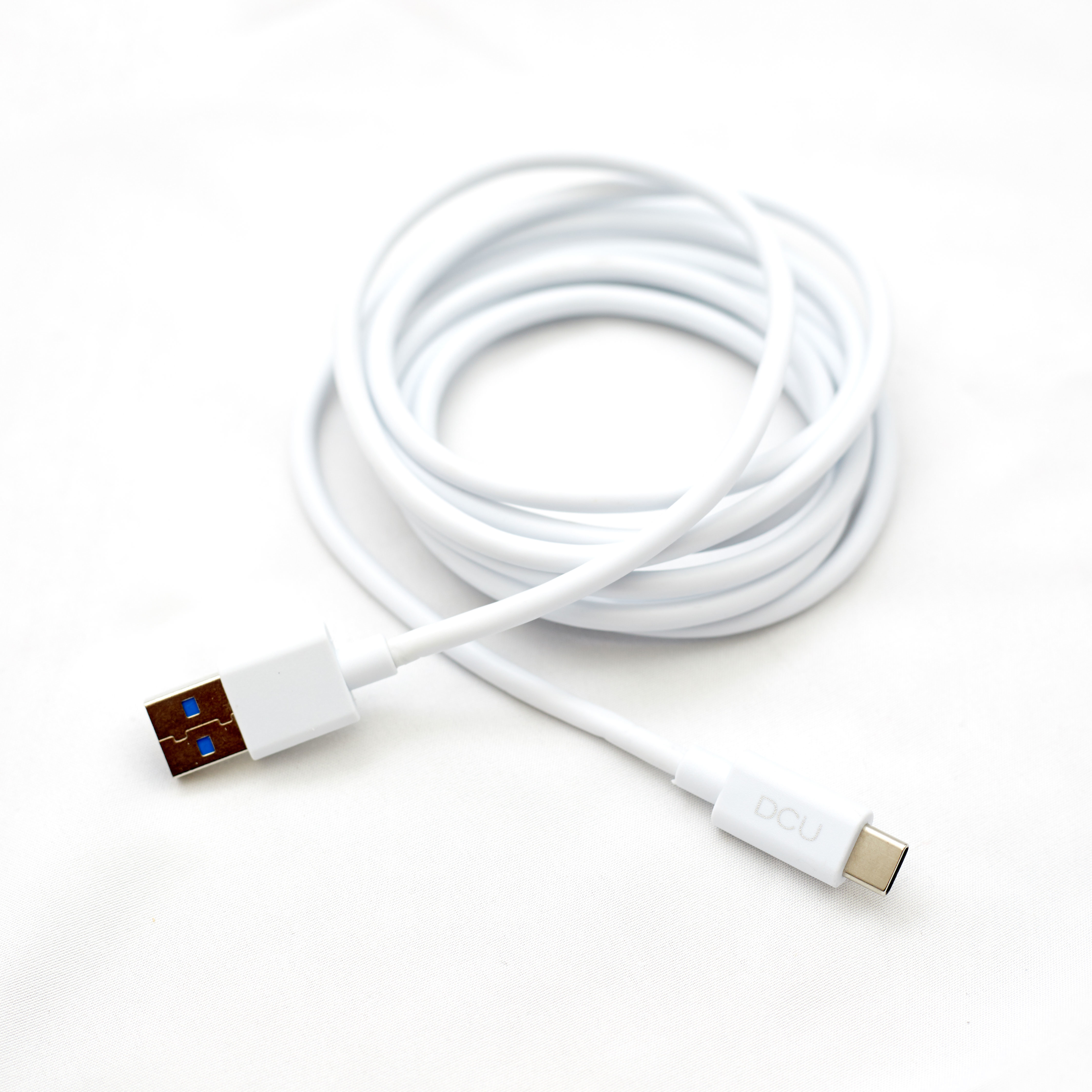 Cavo USB bianco, arrotolato, con connettori a ciascuna estremità su una superficie bianca.