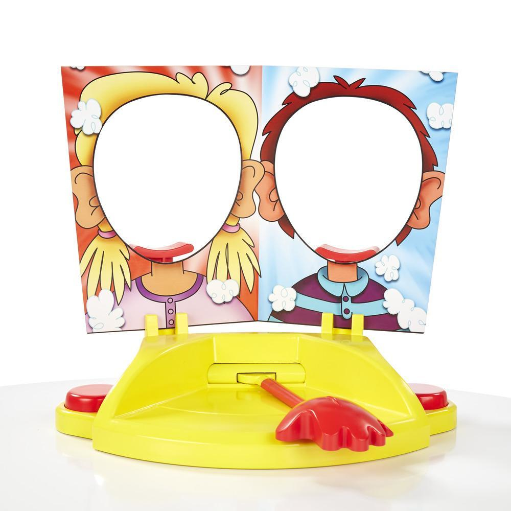 Konfiguracja gry Pie Face z żółtą podstawą, otworami na twarze i czerwonym uchwytem. Widoczne dwa wycięcia twarzy.