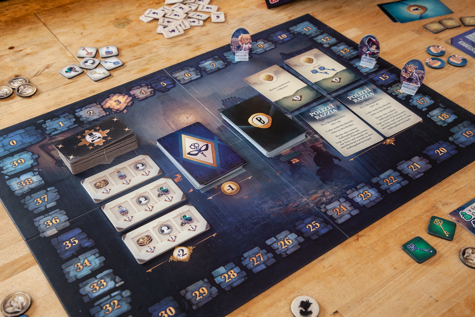 Configuración de juego de mesa con cartas, fichas y un tablero numerado con una escena urbana.