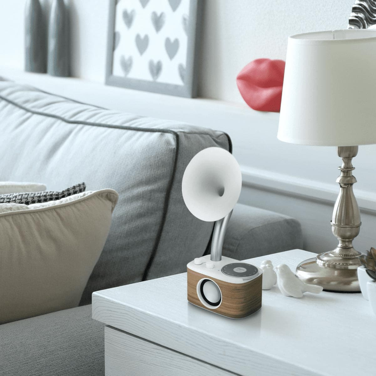Mały, brązowo-biały głośnik w stylu retro na białym stole, obok lampy.