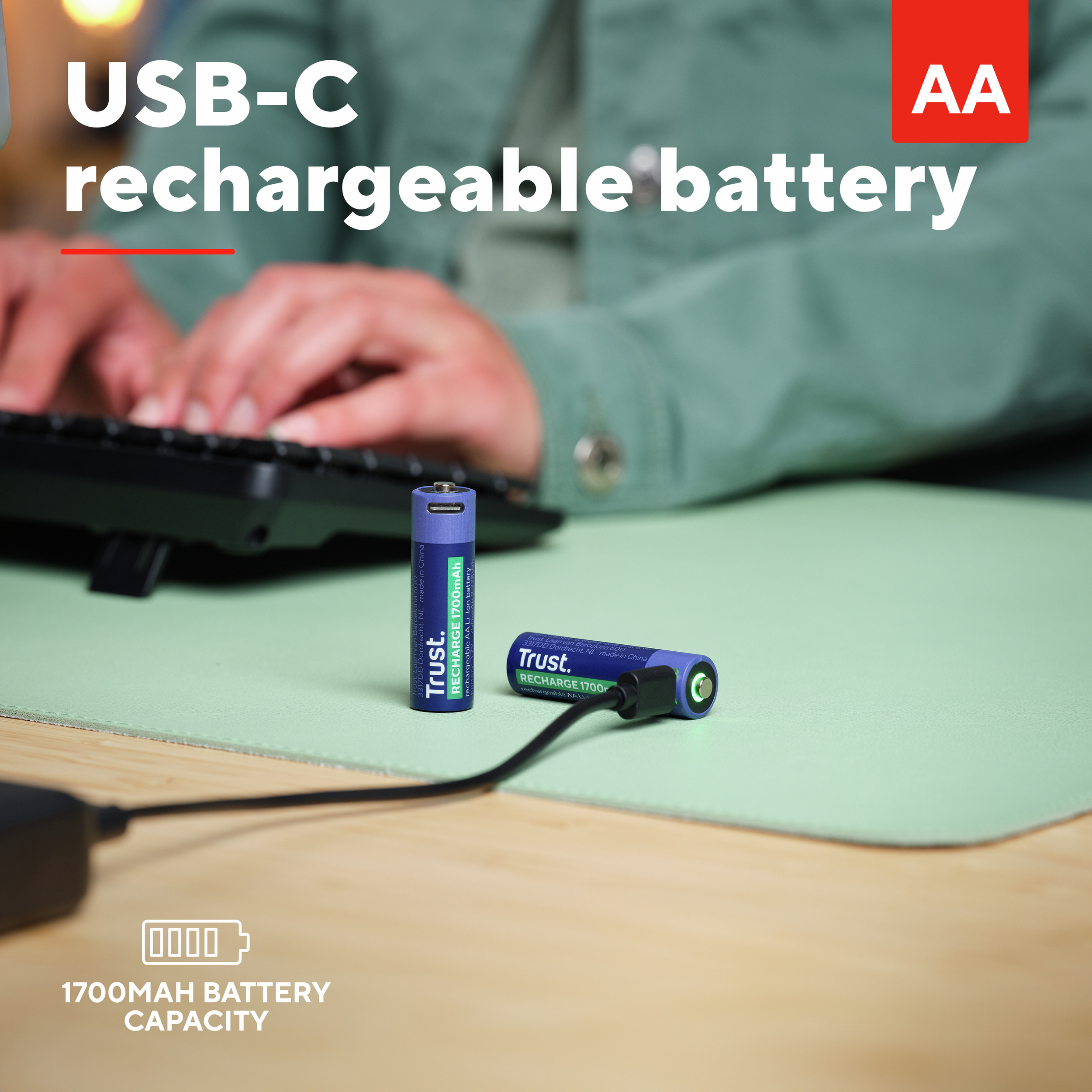 Batteria AA ricaricabile con ricarica USB-C. Persona che digita sulla tastiera su un tappetino verde.